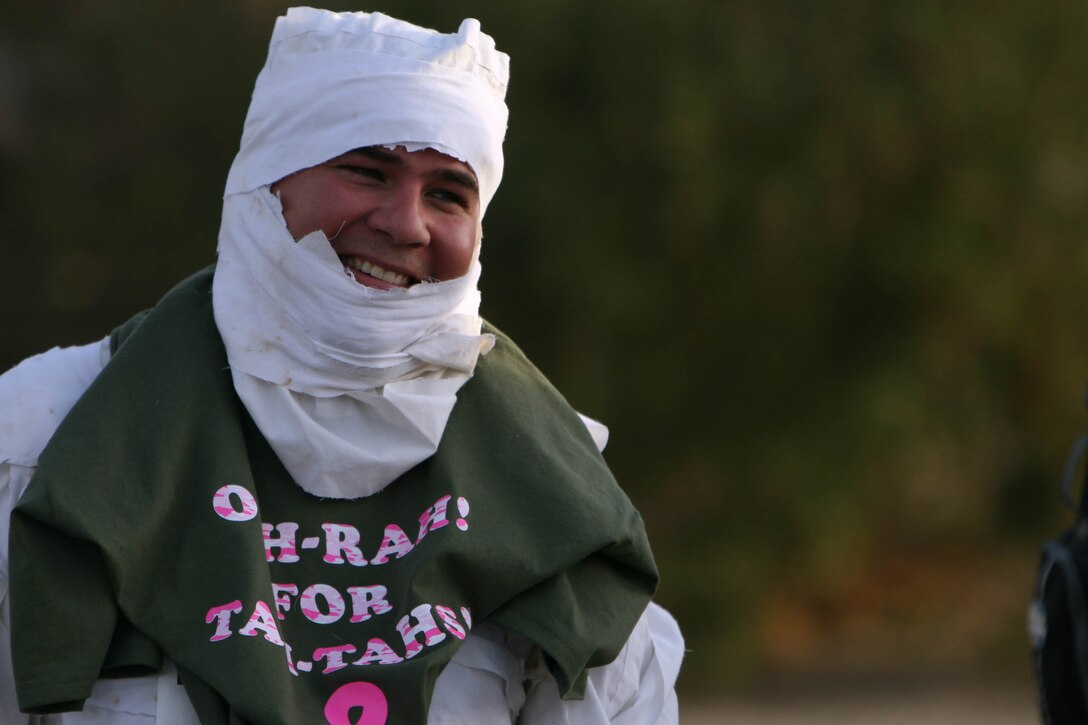 Osvaldo Chacon cracks a smile after completing the Marine Corps Communications-Electronics School Fun Run dressed as a mummy Oct. 30. Chacon also sported an "Ooh-Rah for Tah Tahs," T-shirt to help support breast cancer awareness.