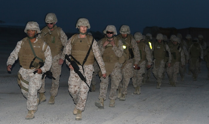 Naval officers aboard Camp Al Taqaddum, Iraq, conducted a hike led by First Sgt. Theresa G. Harris (front right), Headquarters and Service Company first sergeant and Capt. George D. Camia (front left), the company commander, as a requirement to receive their Fleet Marine Force Qualified Officer pins, Oct. 31, 2009.  The hike is just one crucial step the sailors have to complete in order to receive their pin; an honor available to only those sailors who serve side-by-side with Marines.  (U.S. Marine Corps photograph by Lance Cpl. Melissa A. Latty)