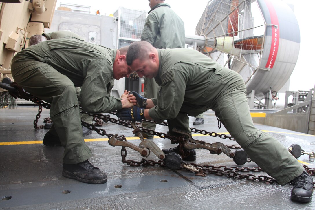 Petty Officer 1st Class David Rader and Chief Rick Scozzafava with Assault Craft Unit Four chain down an Amphibious Assault Vehicle before making the trip from Onslow Beach on Camp Lejeune, N.C. to USS New York, Oct. 30, 2009. USS New York will be commissioned in New York City Nov. 7, where Marines from Special Purpose Marine Air Ground Task Force 26 will display expeditionary capabilities.