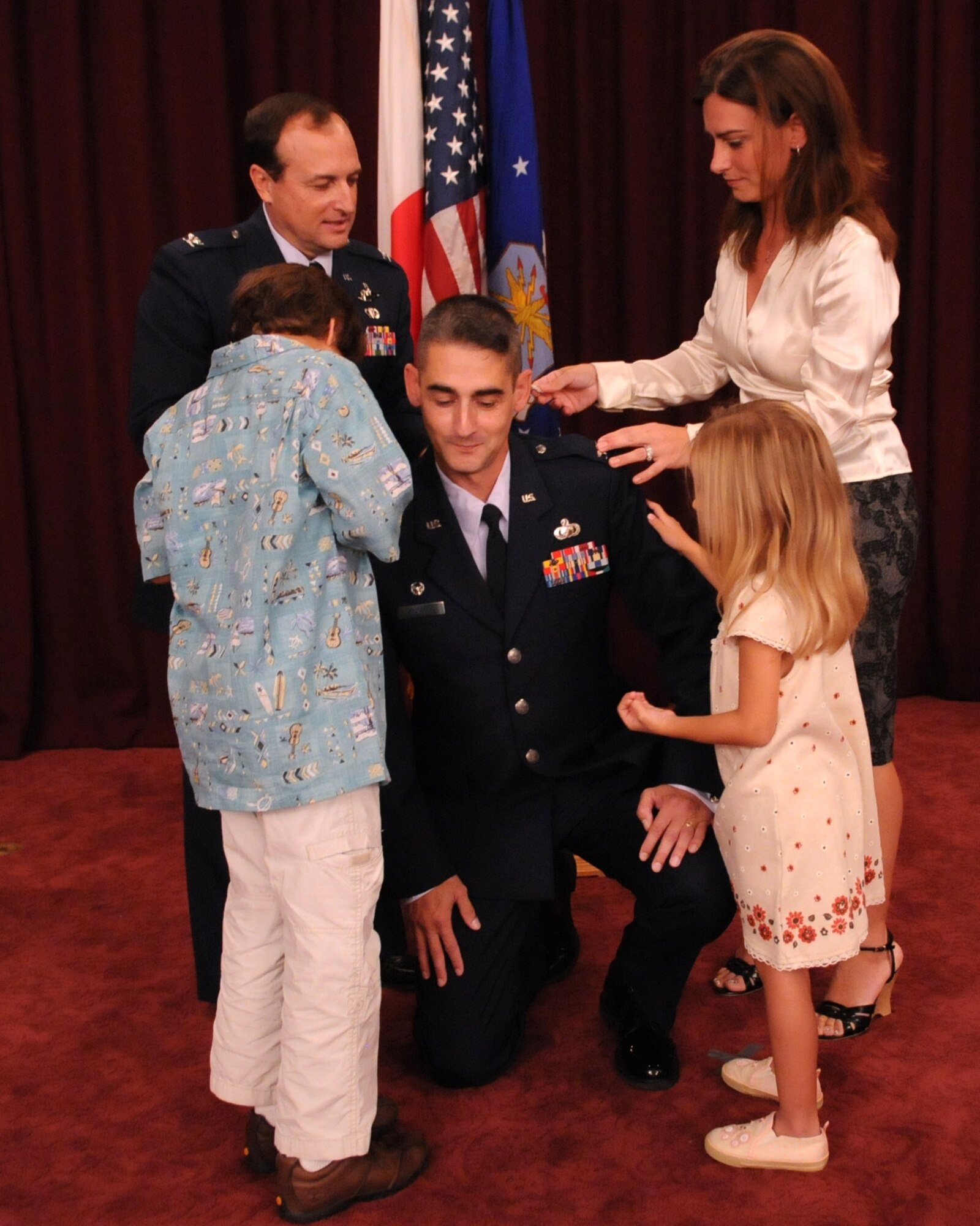 Colonel Mario Troncoso, 18th Force Support Squadron commander, has his new rank pinned on by his wife, Inanc, son Mario, daughter Smyrna and Col. Kelly Fletcher, 18th Mission Support Group commander, Oct. 30 at the Kadena Officers' Club. (U.S. Air Force photo / Airman 1st Class Amanda Grabiec) 