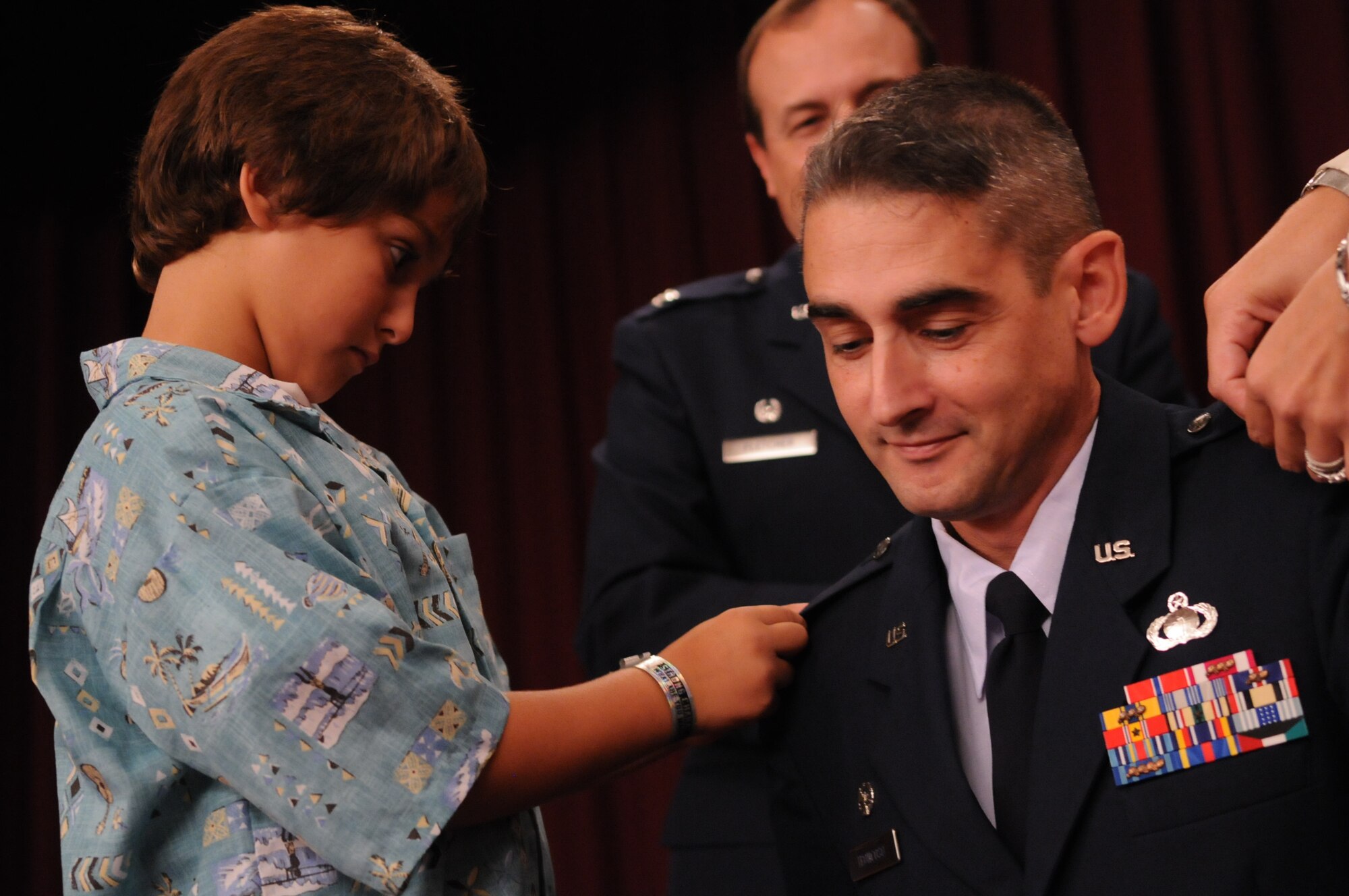 Colonel Mario Troncoso, 18th Force Support Squadron commander, has his new rank pinned on by his son Mario Oct. 30 at the Kadena Officers' Club. (U.S. Air Force photo / Airman 1st Class Amanda Grabiec)