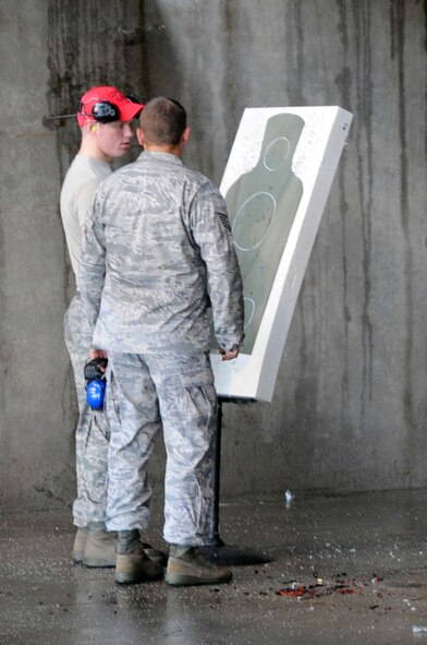 After Airmen have shot practice rounds, instructors count how many rounds have hit the target and provide on the spot adjustment training to the qualifiers. (U.S. Air Force photo by Airman 1st Class Brittany Y. Bateman)(RELEASED)
