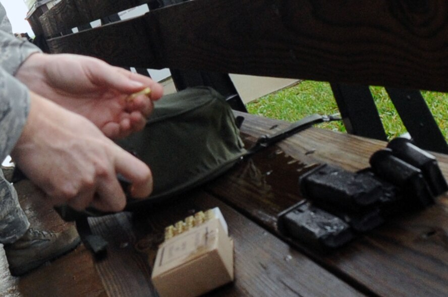 Students begin to load their magazines at the firing range after the classroom portion and safety briefings. (U.S. Air Force photo by Airman 1st Class Brittany Y. Bateman)(RELEASED)