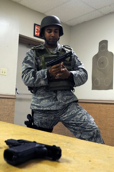 Staff Sgt. Matthew Denny, 2d Security Forces Squadron combat arms instructor, shows students how to properly use an M-9 Beretta semiautomatic weapon during the classroom portion of qualification training. (U.S. Air Force photo by Airman 1st Class Brittany Y. Bateman)(RELEASED)