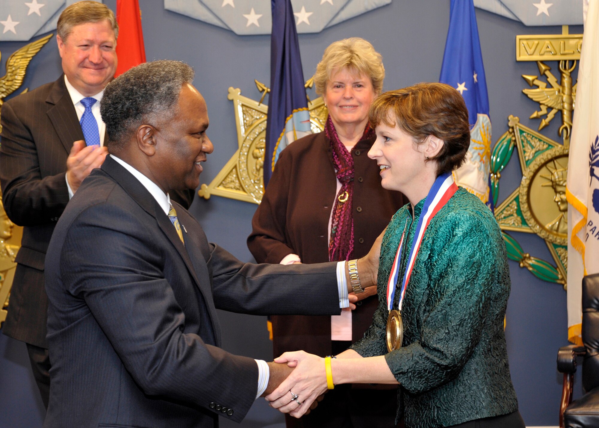 Horace Larry, deputy director of Air Force Services, congratulates Virginia Dosedel, recipient of the Spirit of Hope Award, as Secretary of the Air Force Michael Donley and Linda Hope, daughter of Bob Hope, look on, Oct. 27, 2009, during a Pentagon ceremony. (U.S. Air Force Photo/Michael Pausic)