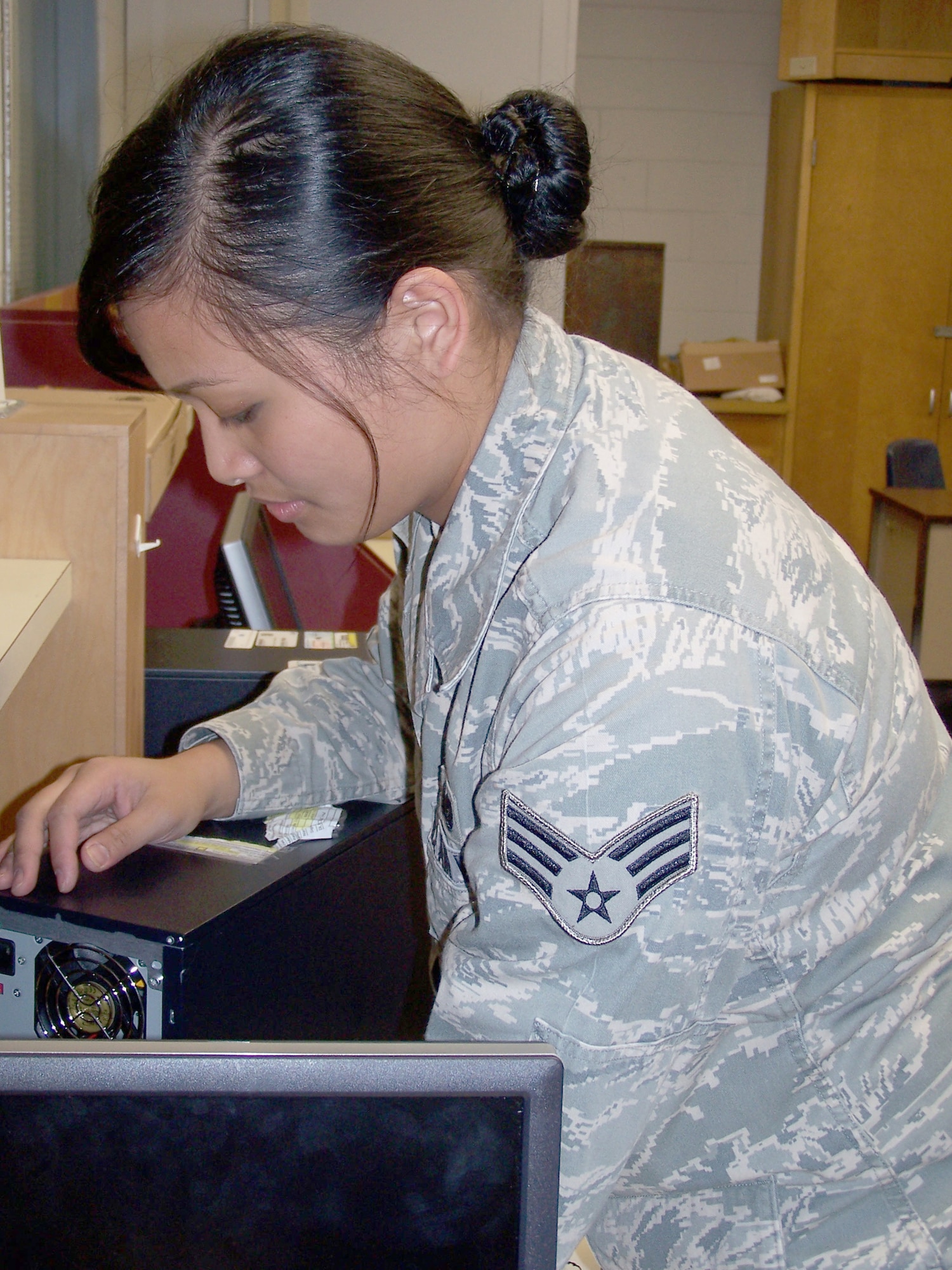 FORT WALTON BEACH, Fla. -- Senior Airman Grace Blazado, 505th Communications Squadron, installs a computer in a study room at Max Bruner Junior Middle School on Oct. 16. The squadron, part of the 505th Command and Control Wing at Hurlburt Field, donated nine computers complete with monitors, keyboards, speakers, Microsoft Office software and new hard drives. Volunteers in the squadron worked on the weekends to condition the computers for immediate use. (U.S. Air Force photo by Noel Getlin)