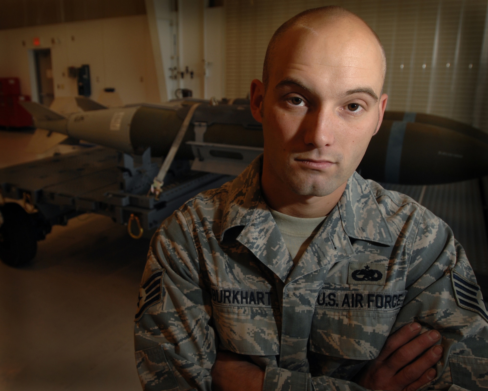 WHITEMAN AIR FORCE BASE, Mo., - Staff Sgt. John Burkhart, 131st Maintenance Squadron conventional maintenance crew chief, poses for a portrait in the 131st munitions maintenance bay, Oct. 23. Sergeant Burkhart is the lead conventional maintenance crew chief for the 131st, teaching munitions maintenance to more than 100 personnel per quarter. Sergeant Burkhart and other members of the 131st MXS build and maintain 11 different types of guided weapons. (U.S. Air Force photo/Senior Airman Kenny Holston)(Released) 