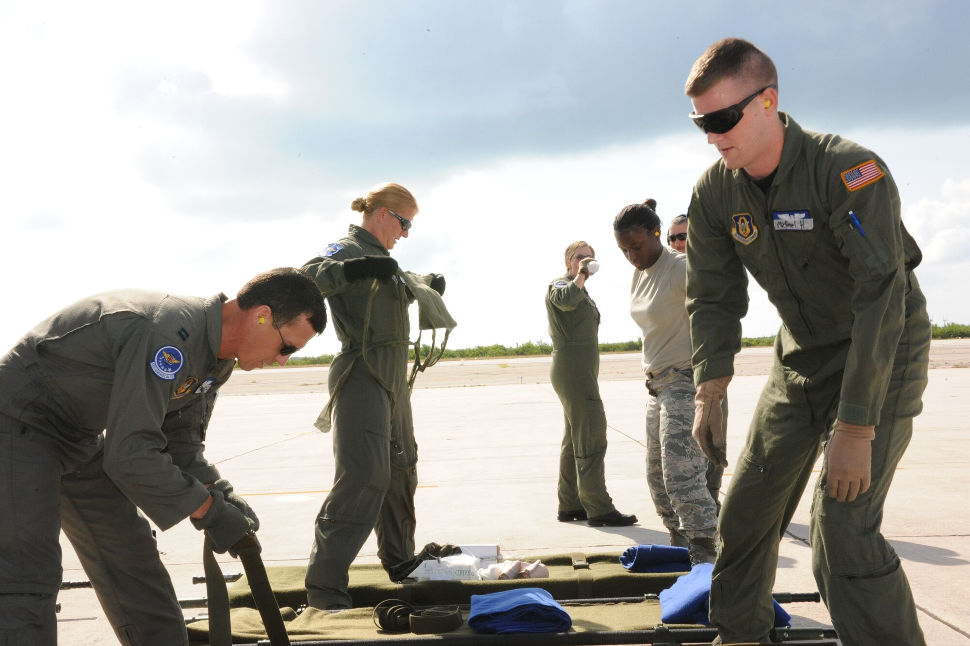 Aircrew members check straps and equipment prior to loading upon an airplane in the humidity of Florida.  The aeromedical members took part in weekend training to prepare them to care for patients in the real world.  (U.S. Air Force photo by Maj. Stan Paregien)