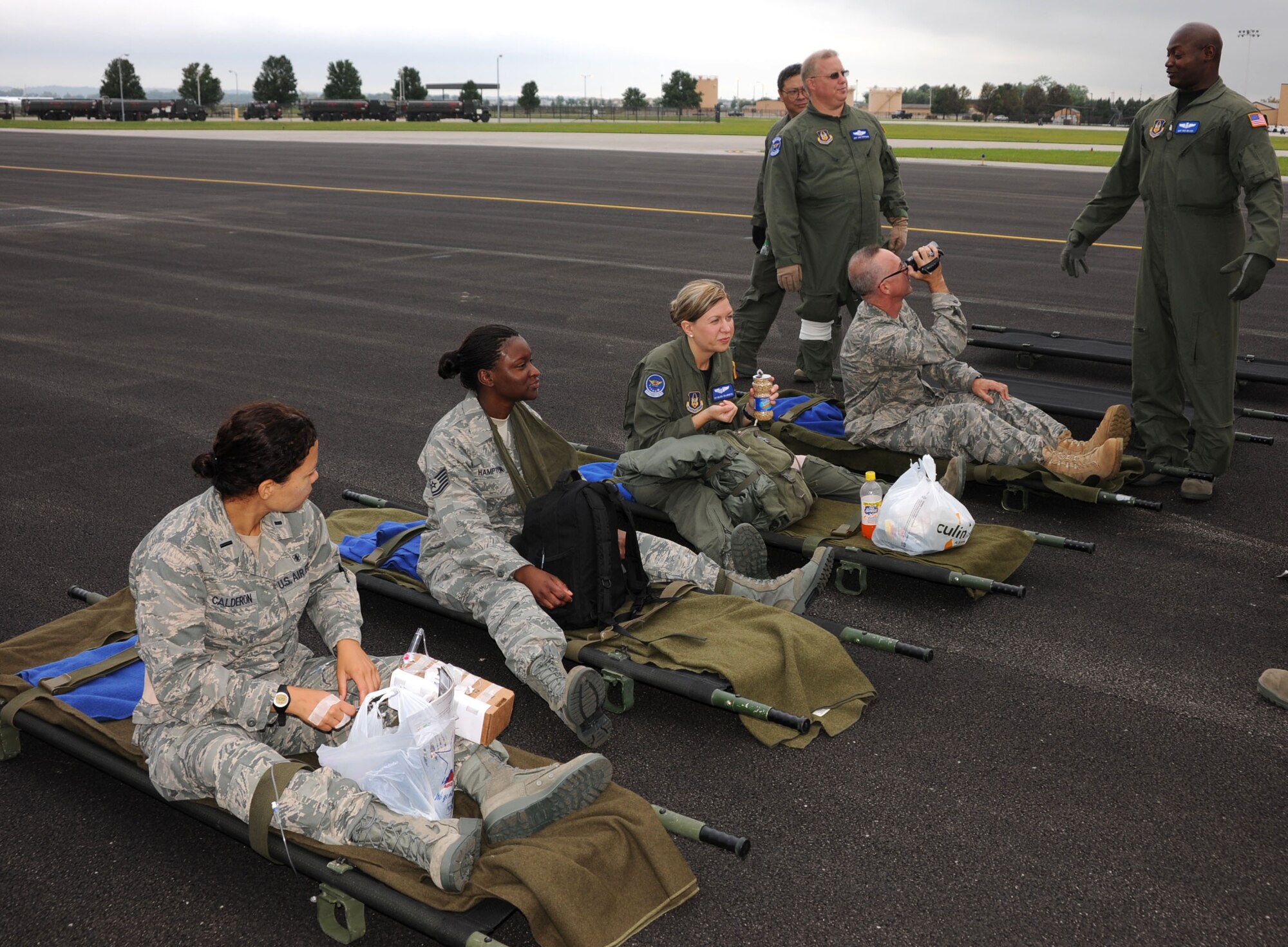 Four practice patients sit on their litters waiting for the arrival of a plane to pick them up during 932nd Aeromedical Evacuation training.  (U.S. Air Force photo/Tech. Sgt. Gerald Sonnenberg)