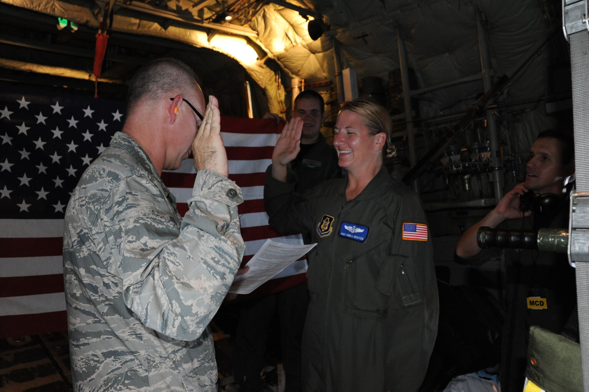 Senior Master Sgt. Angela Graffen takes a new oath of enlistment from an officer at 28,000 feet during a C-130 aircraft training flight with the 932nd Airlift Wing.  (U.S. Air Force photo/Tech. Sgt. Gerald Sonnenberg)