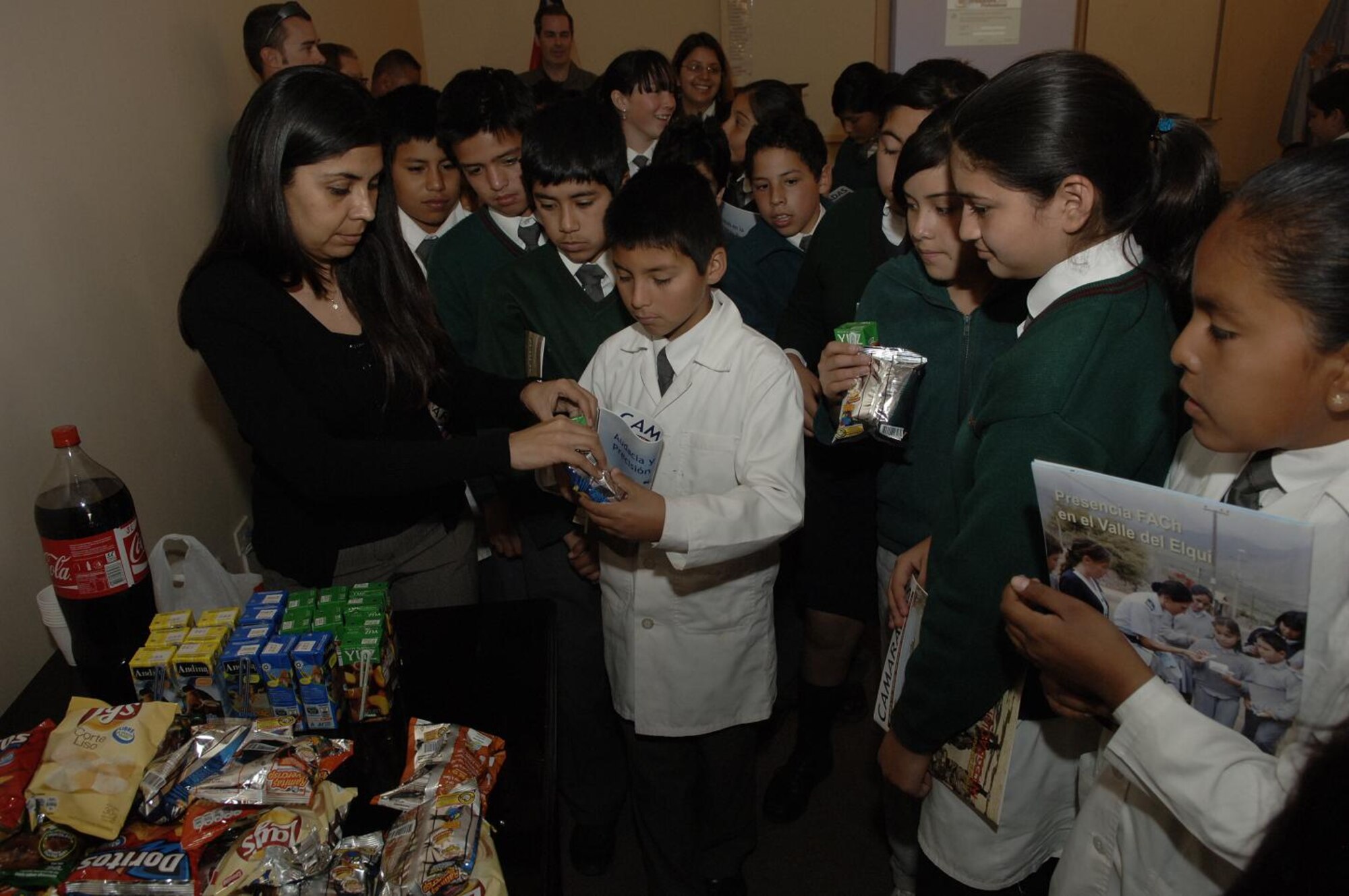 IQUIQUE, Chile -- Patricia Vidal, Fuerza Aerea De Chile public affairs officer, hands out snacks to students of Colegio Macaya during a base tour here Oct. 30. Students were invited to the base to see U.S. and Chilean Air Force aircraft, and meet Airmen. (U.S. Air Force photo by Tech. Sgt. Eric Petosky)