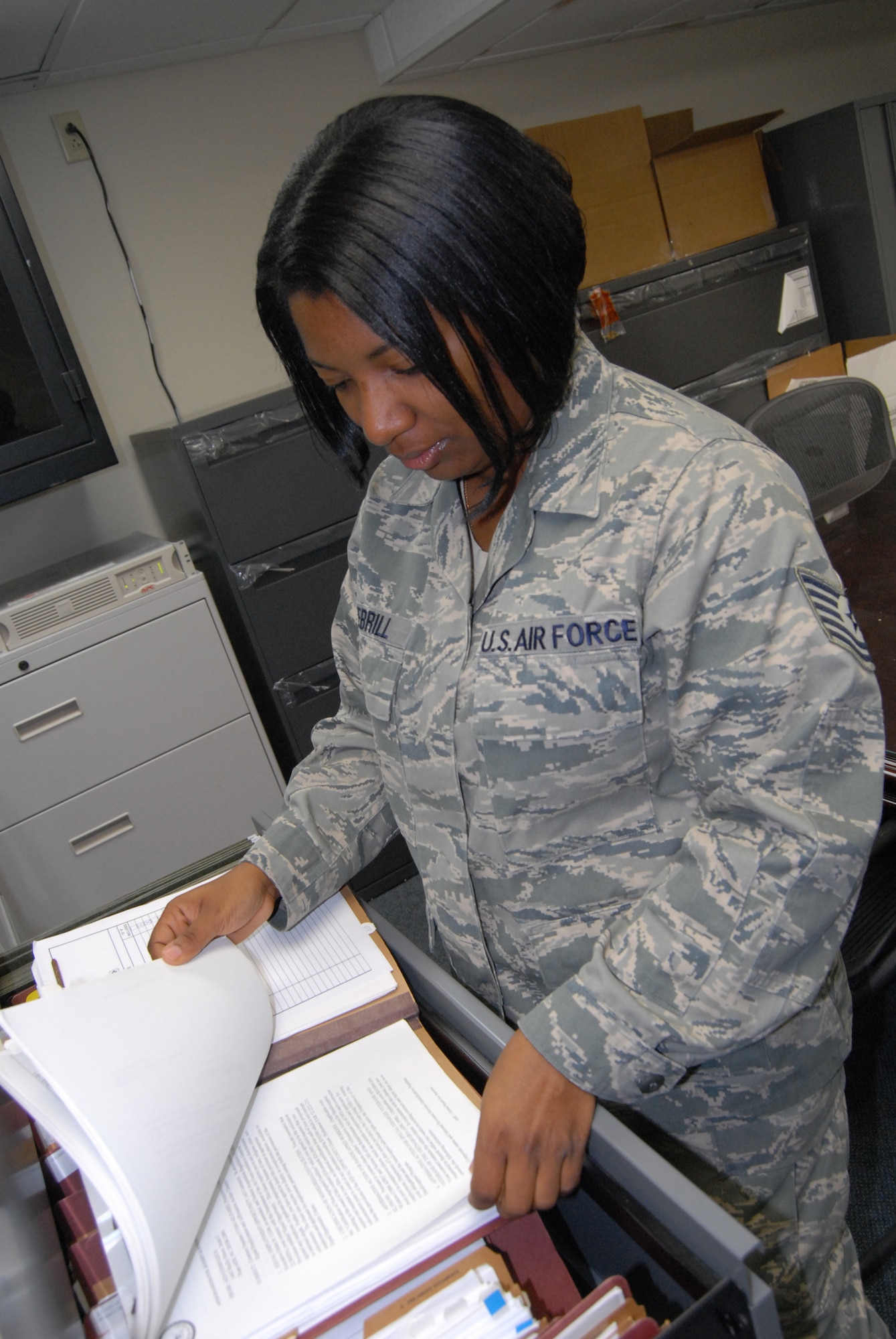 Tech. Sgt. Tawanda Debrill, 43rd Contracting Squadron, looks over completed contracts in the file room Oct. 27 as part of her job as a contract specialist 