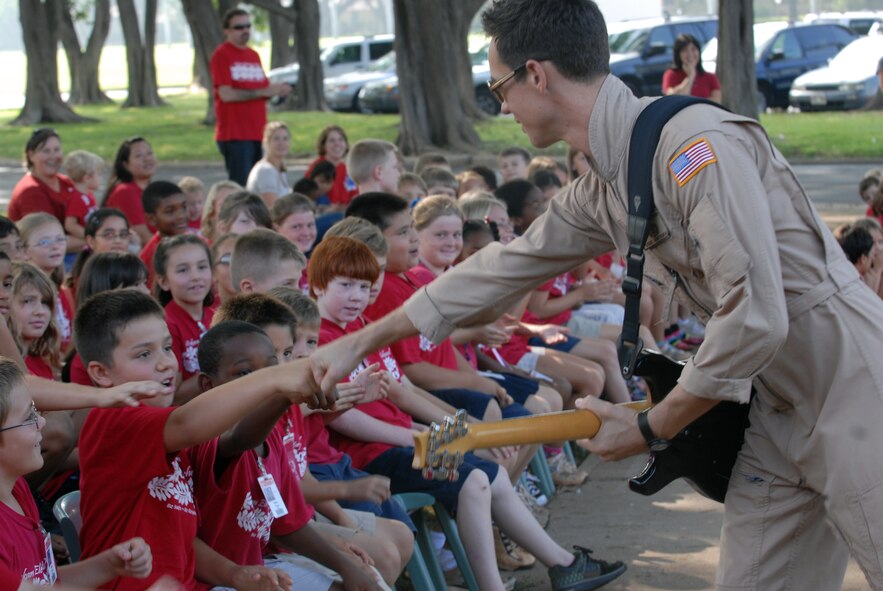 HICKAM AIR FORCE BASE, Hawaii -- Staff Sgt. Johnny Kukan, U.S. Air Force Band of the Pacific guitarist, greets Hickam Elementary School students here, Oct. 29. Hickam, one of two elementary schools on base, was one of six schools the band performed for in support of Red Ribbon Week. Red Ribbon Week focuses on living and maintaining a drug free lifestyle. (U.S. Air Force photo/Senior Airman Gustavo Gonzalez)