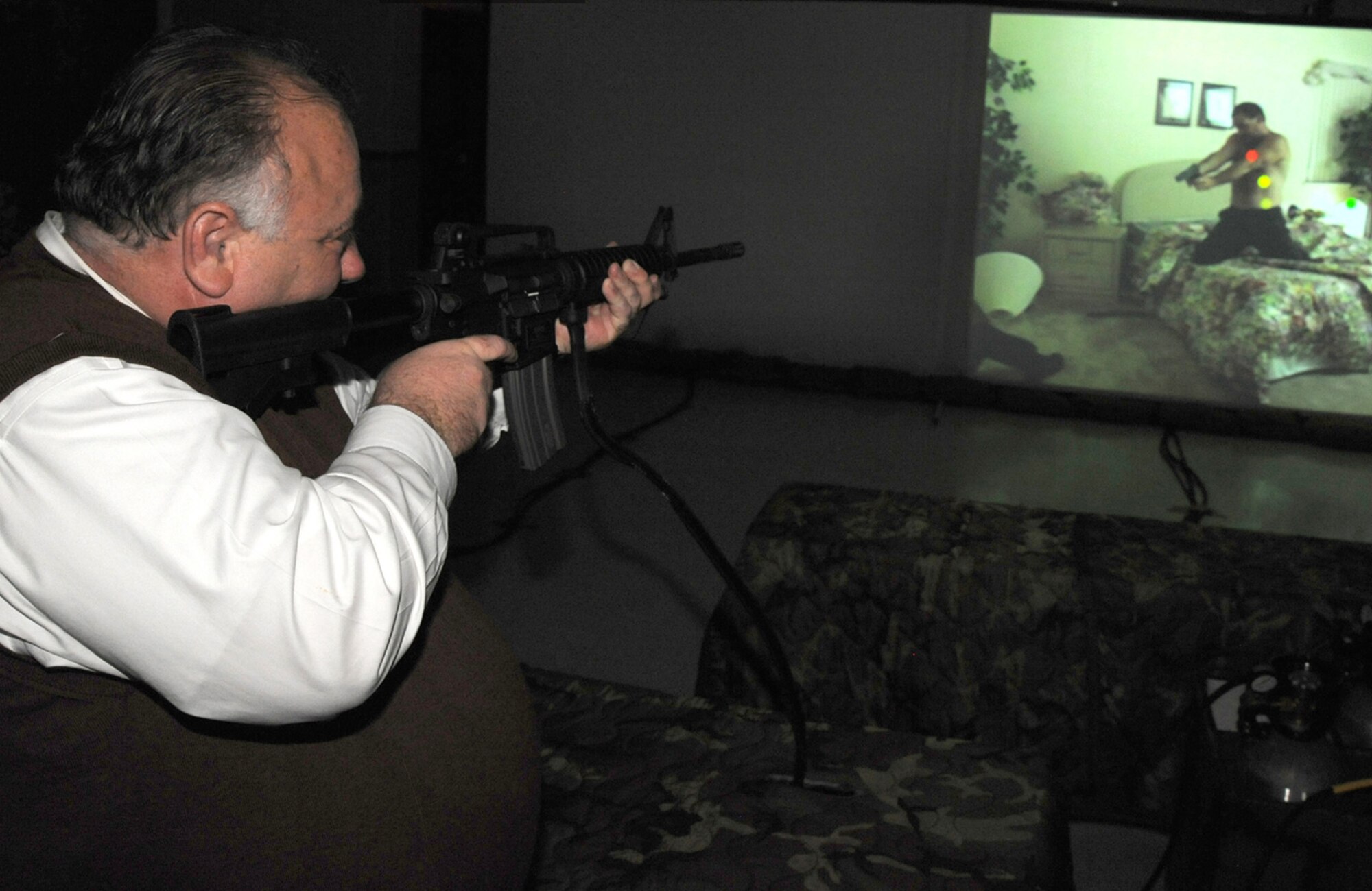 Derby Police Chief Robert Lee takes aim during an M-4 rifle simulator demonstration at McConnell Air Force Base, Kan., on Oct. 29. The video game-like demo was part of an orientation tour for McConnell's honorary commanders. Lee is the honorary commander of the 931st Mission Support Flight, an Air Force Reserve unit at McConnell. Derby is a town just south of the base. (U.S. Air Force photo/Tech. Sgt. Chyrece Campbell)