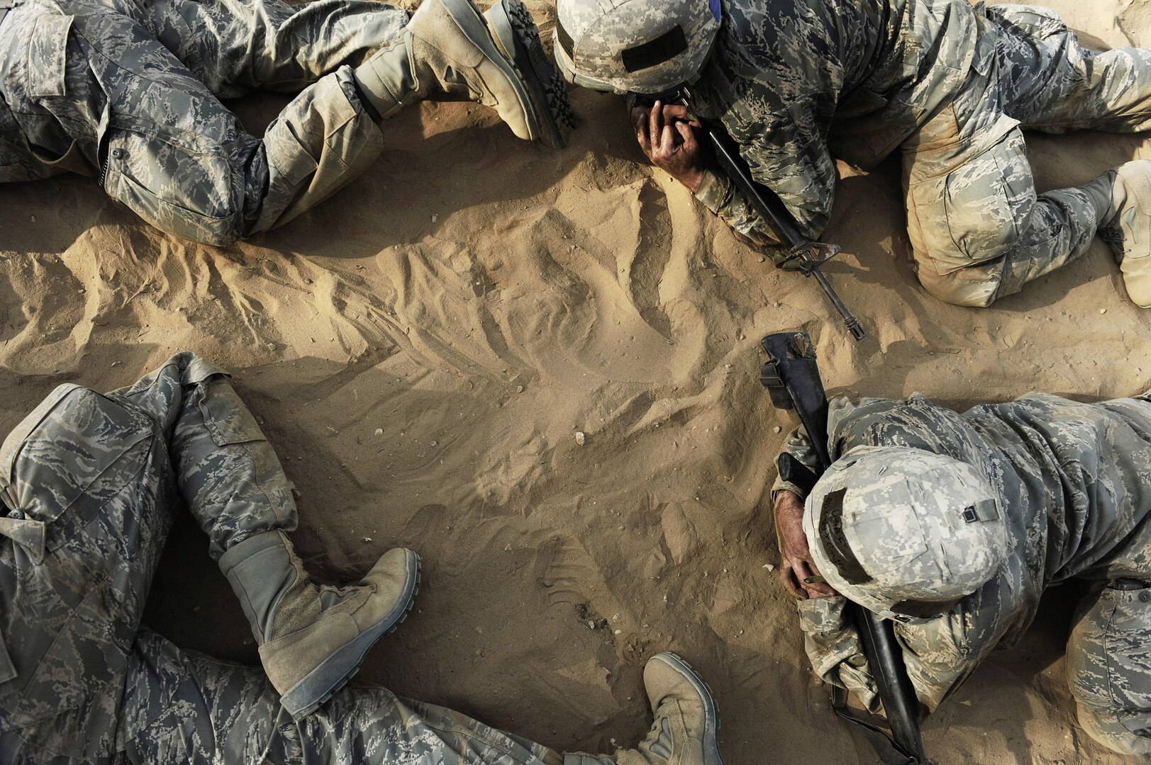 Basic trainees low crawl through a tactical course at the Basic Expeditionary Airman Skills Training course. BEAST replicates the sights, sounds and emotions Airmen will experience in the deployed environment. (U.S. Air Force photo/Senior Airman Christopher Griffin)