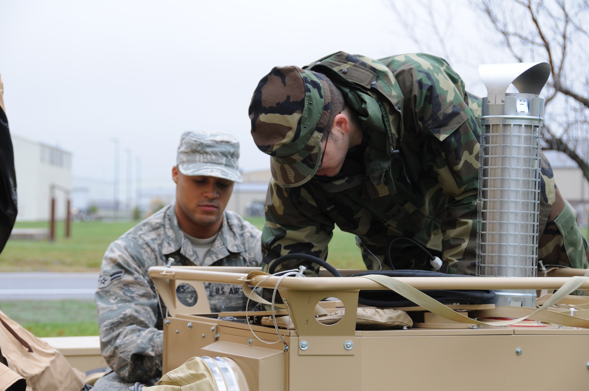 Senior Airman Chance Soda, (BDU's)107th Airlift Wing, Civil engineering Squadron works alongside Airman 1st Class Steven Jones, (ABU's)106th Rescue Wing, Civil Engineering Squadron, Long Island, N.Y. The Airmen are preparing a self contained mobile heater for use. The heating system comes complete with duct work, thermostat and a carbon monoxide detector. The heaters are part of a new rapid deployment shelter system designed to temporary house military responders in time of a natural or manmade disaster.  Airman Jones has traveled to Niagara in support of the Vigilant Guard exercise that will run the week of Nov. 1 through Nov. 6. (USAF Photo/SSgt. Peter Dean)