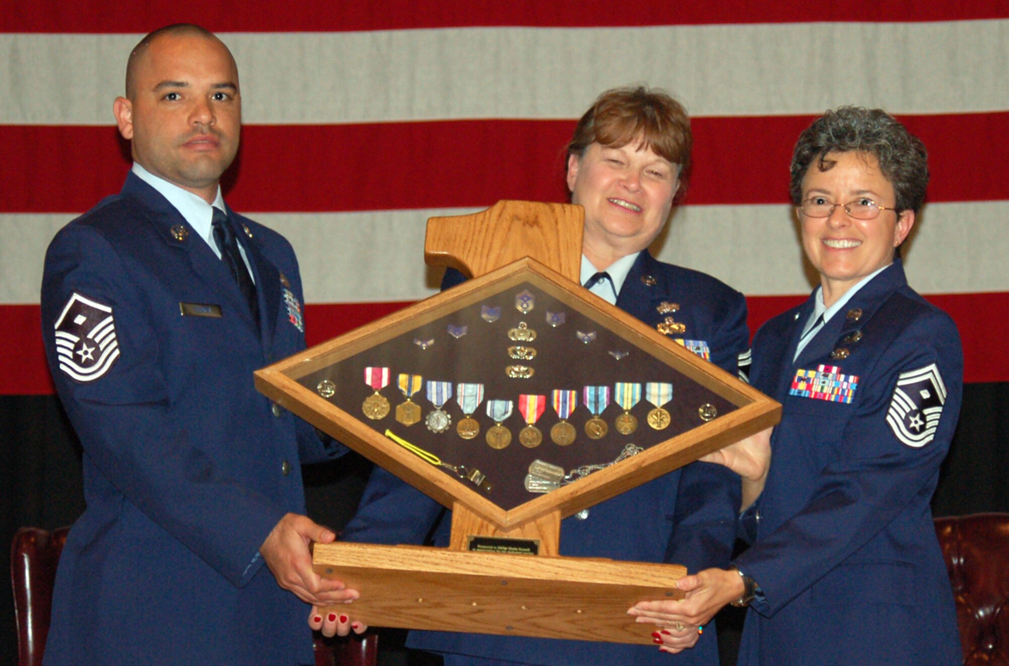 Senior Master Sgt. Sheila Russell, 931st Aircraft Maintenance Squadron first sergeant, retired from her 37-year Air Force career during a ceremony at McConnell Air Force Base, Kan., on Oct. 18. Presenting her a ceremonial gift were fellow first sergeants, Senior Master Sgt. Sheila Croninger and Master Sgt. Willie Tucker. (U.S. Air Force photo/Staff Sgt. John Allen)