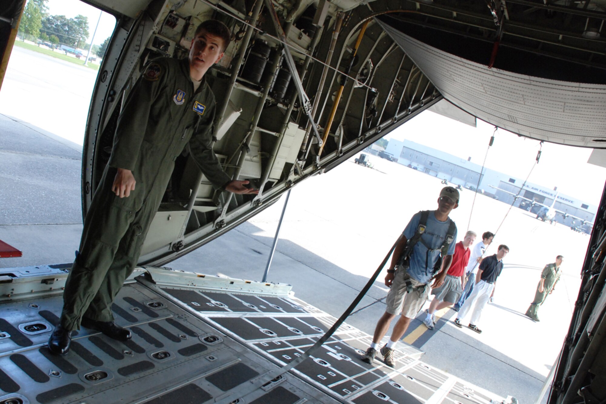 Senior Airman Andrew R. Alexandersen, loadmaster, 700th Airlift Squadron, demonstrates the use of a C-130H aircraft safety harness to a member of the Georgia Tech University Flying Club during a base tour Oct. 9. (U.S. Air Force photo/Tech. Sgt. James Branch)