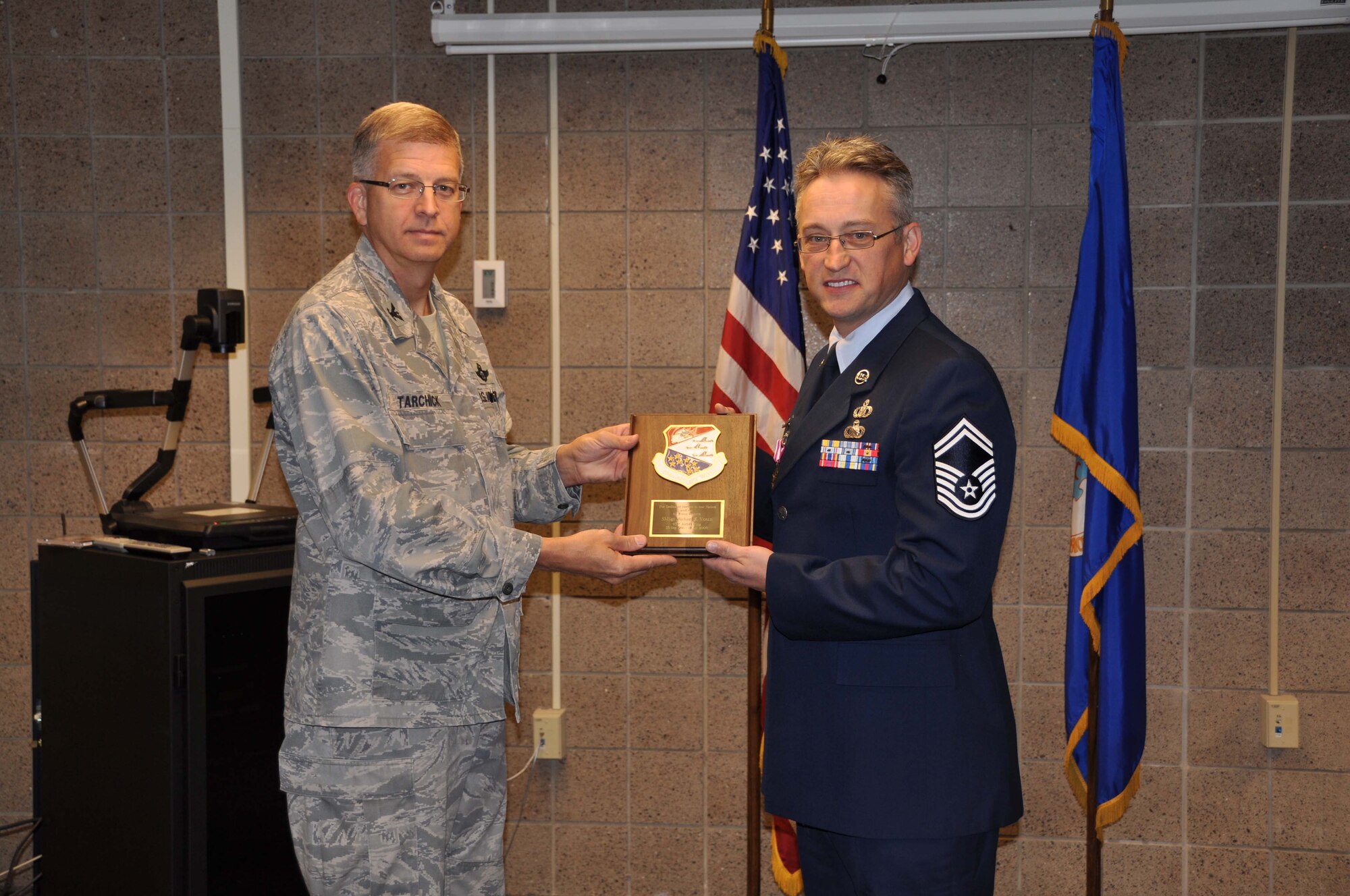 Senior Master Sgt. Mike Vosen, 934th Airlift Wing Safety, receives his retirement plaque from Col. Tim Tarchick, 934th Airlift Wing commander Oct. 3. Sergeant Vosen retired with 26 years of service.(Air Force Phot/Tech. Sgt. Bob Sommer)