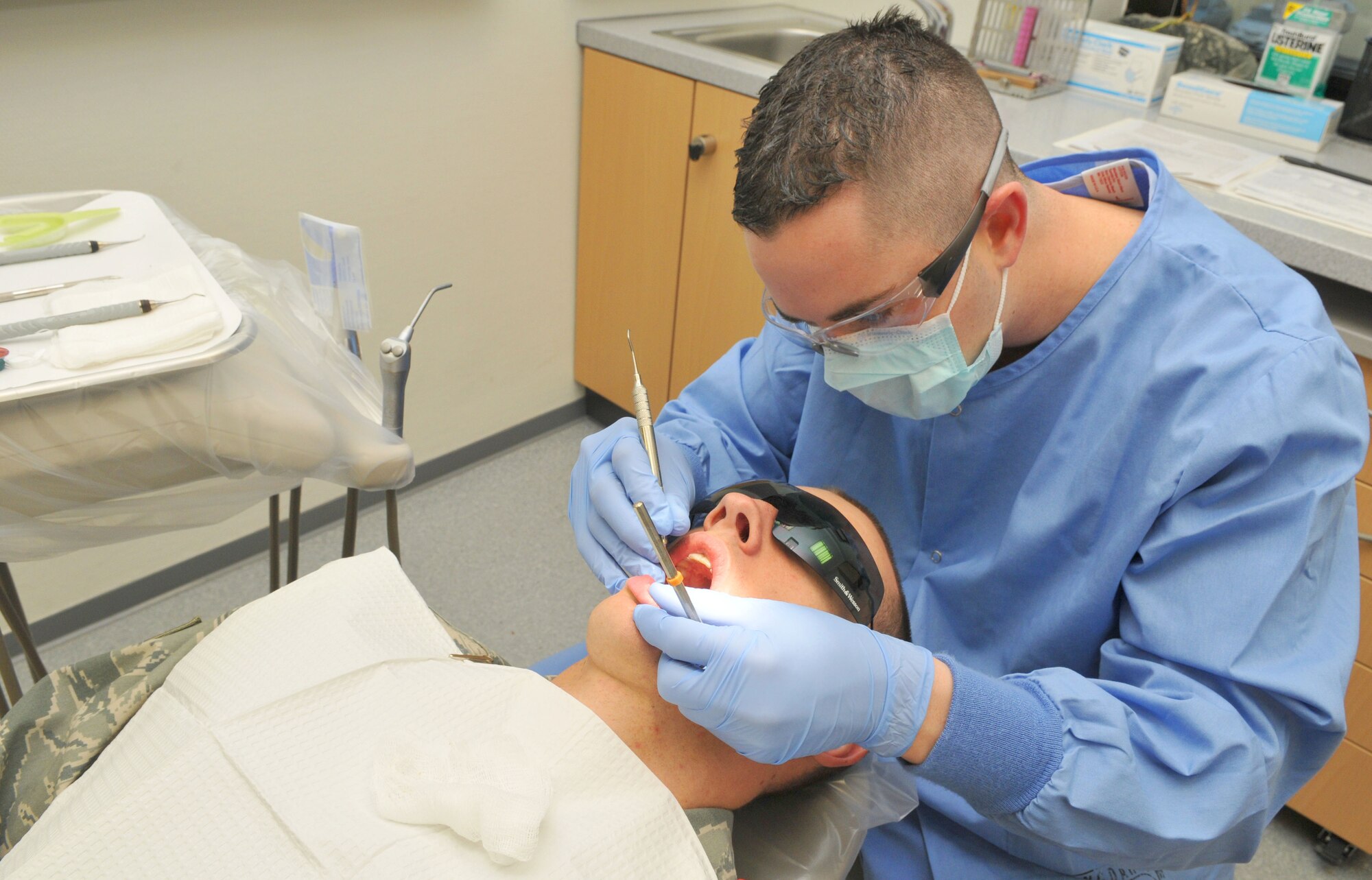 SPANGDAHLEM AIR BASE, Germany -- Senior Airman Joshua Barnes, 52nd Dental Squadron, performs an oral cleaning on Senior Airman Sam Davis, 52nd Logistics Readiness Squadron, Oct. 29. Active-duty patients receive a dental exam and cleaning at least once a year or 90 days prior to deployments. (U.S. Air Force photo/Airmen 1st Class Nick Wilson)