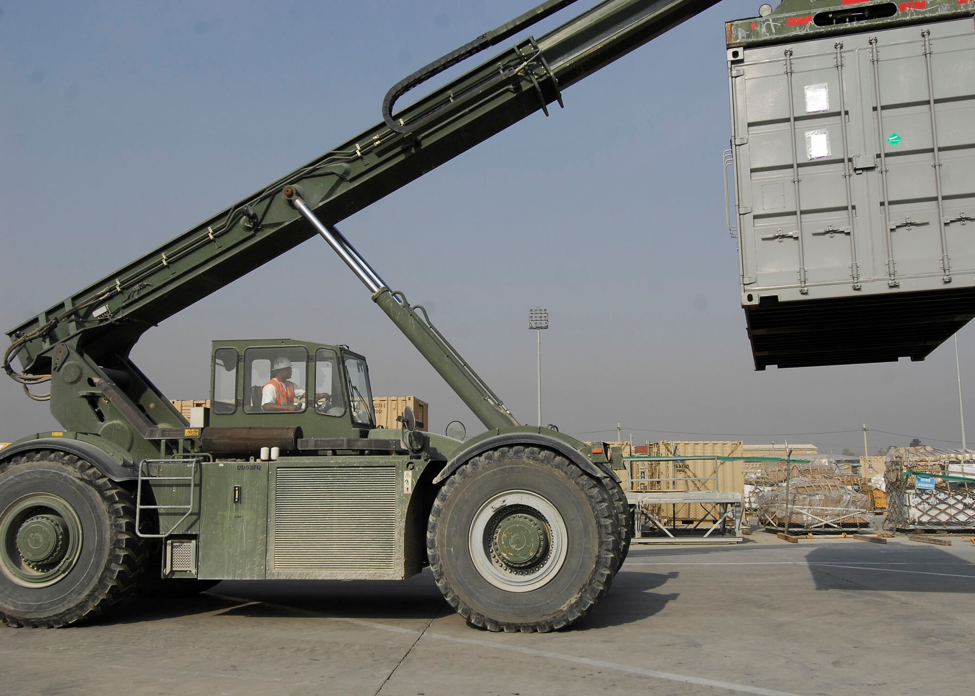 BAGRAM AIRFIELD, Afghanistan -- Mr. Randy Pryor, a civilian contractor, assists the 455th Expeditionary Aerial Port Squadron moving shipping containers Oct. 30, 2009.  The 455th EAPS received multiple shipping containers, which can be used for anything from offices to living quarters.  Instead of having the shipping containers sit on K loaders the Air Force, Army and civilian contractors teamed up and moved them to the Army's supply yard.  Mr. Pryor, a native of Sulphur Springs, Texas, said "I love supporting the military, that's why I'm here."  (U.S. Air Force photo/Senior Airman Felicia Juenke)