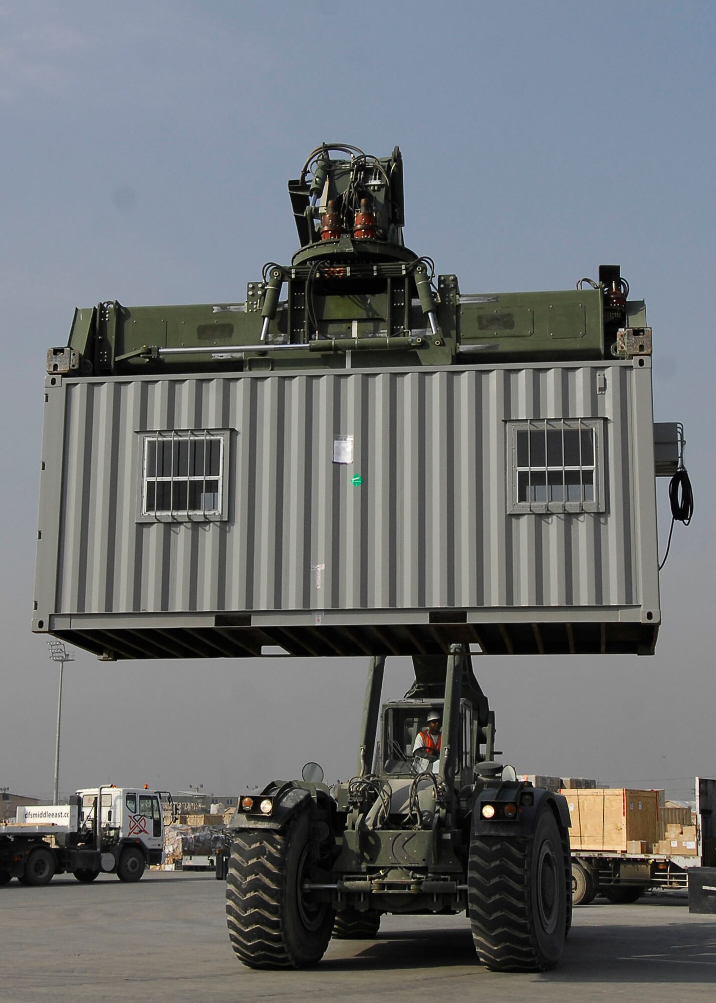 BAGRAM AIRFIELD, Afghanistan -- Mr. Randy Pryor, a civilian contractor, uses a rough terrain cargo handler to move shipping containers to a heavy expandable mobility tactical truck (HEMTT) Oct. 30, 2009.  The HEMTT is being used to transport the shipping containers to the Army's supply yard.  The shipping containers can be used for various things including offices or living quarters.  Mr. Pryor, a native of Sulphur Springs, Texas, said "I love supporting the military, that's why I'm here."  (U.S. Air Force photo/Senior Airman Felicia Juenke)