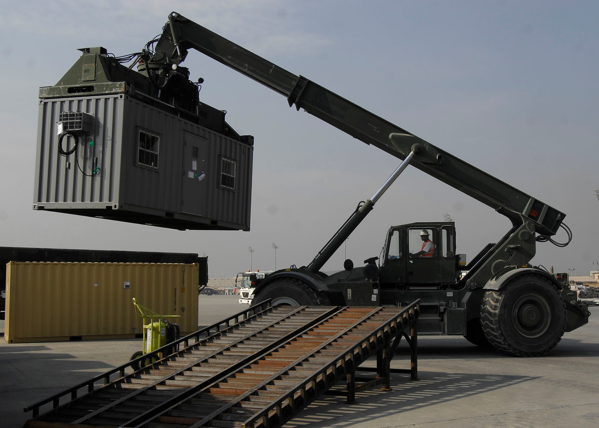 BAGRAM AIRFIELD, Afghanistan -- Mr. Randy Pryor, a civilian contractor, assists the 455th Expeditionary Aerial Port Squadron moving shipping containers Oct. 30, 2009.  The 455th EAPS received multiple shipping containers, which can be used for anything from offices to living quarters.  Instead of having the shipping containers sit on K loaders the Air Force, Army and civilian contractors teamed up and moved them to the Armys supply yard.  Mr. Pryor, a native of Sulphur Springs, Texas, said "I love supporting the military, that's why I'm here."  (U.S. Air Force photo/Senior Airman Felicia Juenke)