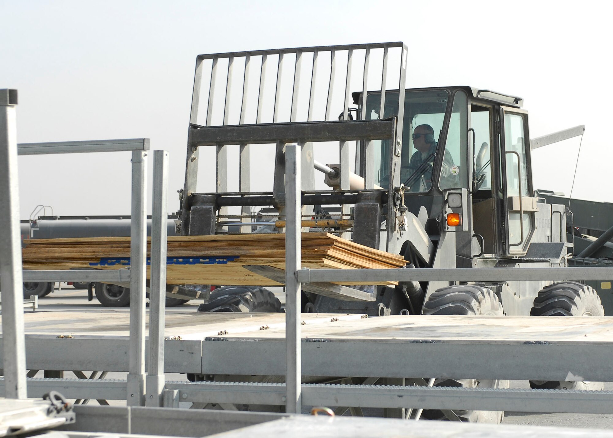 BAGRAM AIRFIELD, Afghanistan -- Tech. Sgt. Gordon Criswell, an air transportation specialist from the 455th Expeditionary Aerial Port Squadron, uses a forklift to remove plywood from a K loader Oct. 30, 2009.  The 455th EAPS received multiple shipping containers, which can be used for anything from offices to living quarters.  Instead of having the shipping containers sit on the K loaders the Air Force, Army and civilian contractors teamed up and moved them to the Army's supply yard.  Sergeant Criswell is deployed from McGuire Air Force Base, N.J., and hails from Ocala, Fla. (U.S. Air Force photo/Senior Airman Felicia Juenke)