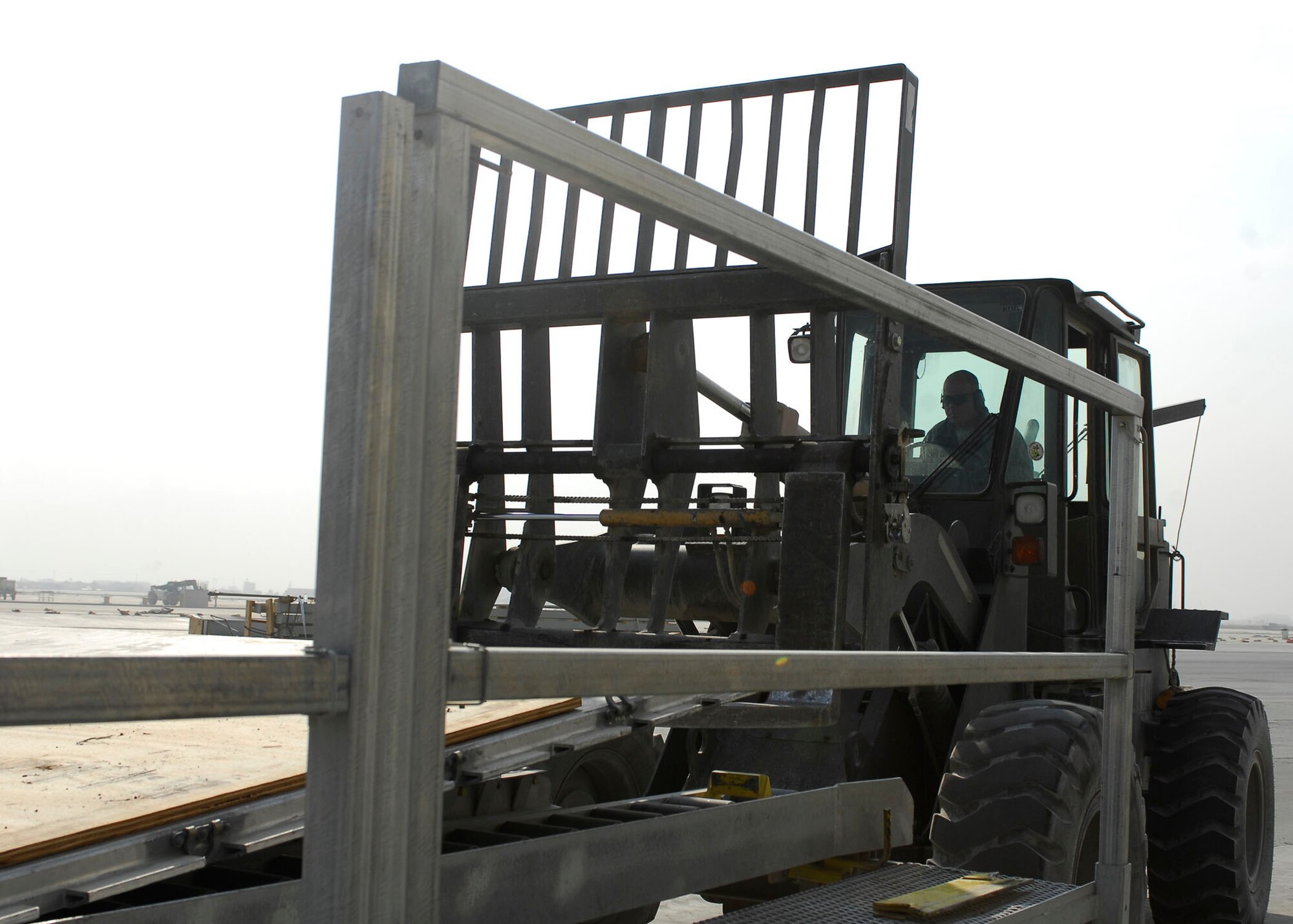 BAGRAM AIRFIELD, Afghanistan -- Tech. Sgt. Gordon Criswell, an air transportation specialist from the 455th Expeditionary Aerial Port Squadron, uses a forklift to remove materials from a K loader Oct. 30, 2009.  The 455th EAPS received multiple shipping containers, which can be used for anything from offices to living quarters.  Instead of having the shipping containers sit on the K loaders the Air Force, Army and civilian contractors teamed up and moved them to the Army's supply yard.  Sergeant Criswell is deployed from McGuire Air Force Base, N.J., and hails from Ocala, Fla.  (U.S. Air Force photo/Senior Airman Felicia Juenke)