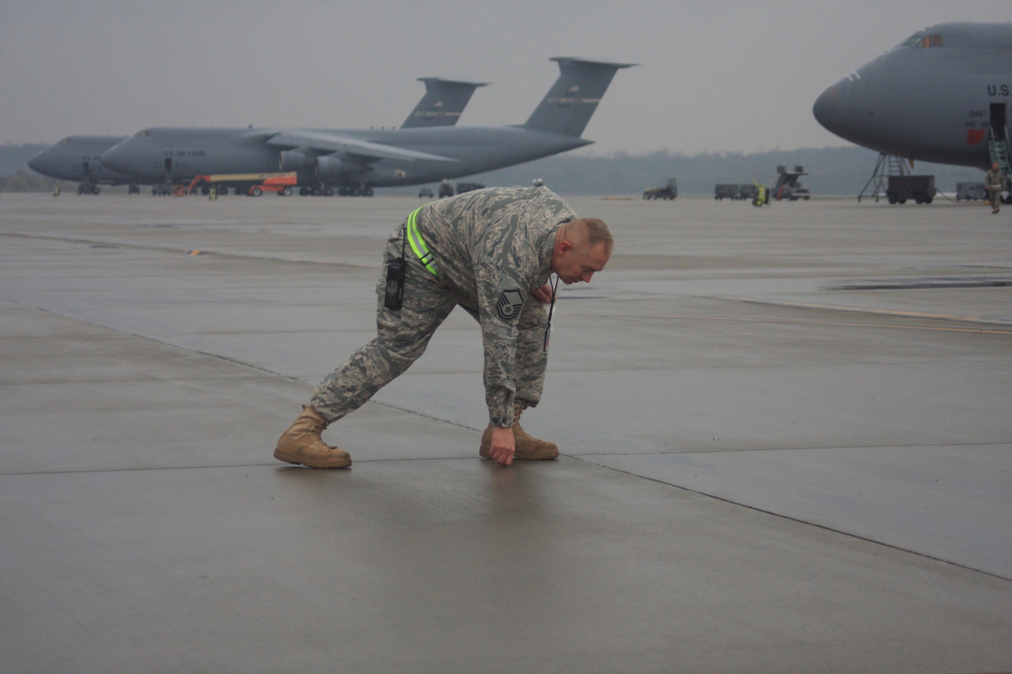 WRIGHT-PATTERSON AIR FORCE BASE, Ohio – Master Sgt. Randy Hodges, 445th Aircraft Maintenance Squadron, picks up a piece of debris he found on the flightline during the wing’s bi-monthly foreign object debris (FOD) walk Oct. 28.  More than 130 reservists and civilians participated, collecting more than four pounds of FOD, which equates to several thousand small stones. FOD on the flightline could be ingested and severely damage aircraft engines.   (U. S. Air Force photo/Senior Airman Mikhail Berlin)
