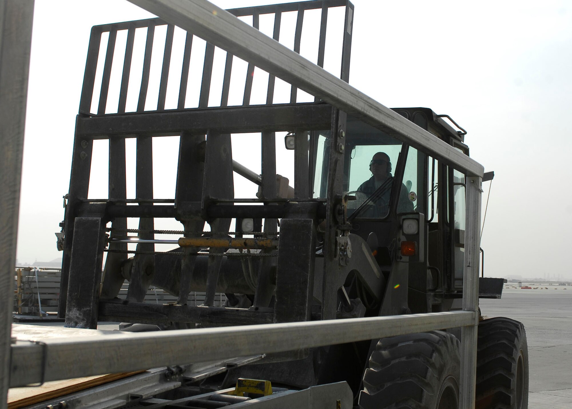 BAGRAM AIRFIELD, Afghanistan -- Tech. Sgt. Gordon Criswell, an air transportation specialist from the 455th Expeditionary Aerial Port Squadron, uses a forklift to remove materials from a K loader Oct. 30, 2009.  The 455th EAPS received multiple shipping containers, which can be used for anything from offices to living quarters.  Instead of having the shipping containers sit on the K loaders the Air Force, Army and civilian contractors teamed up and moved them to the Army's supply yard.  Sergeant Criswell is deployed from McGuire Air Force Base, N.J., and hails from Ocala, Fla.  (U.S. Air Force photo/Senior Airman Felicia Juenke)