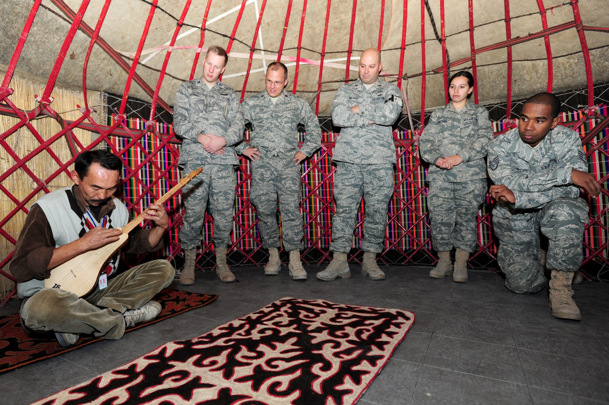 TRANSIT CENTER AT MANAS, Kyrgyzstan -- Airmen gather inside a Kyrgyz Yurt to listen to music played on a komuz as part of Kyrgyz Culture day at the Transit Center, Oct. 24, 2009. (U.S. Air Force photo/Senior Airman Steele C. G. Britton)