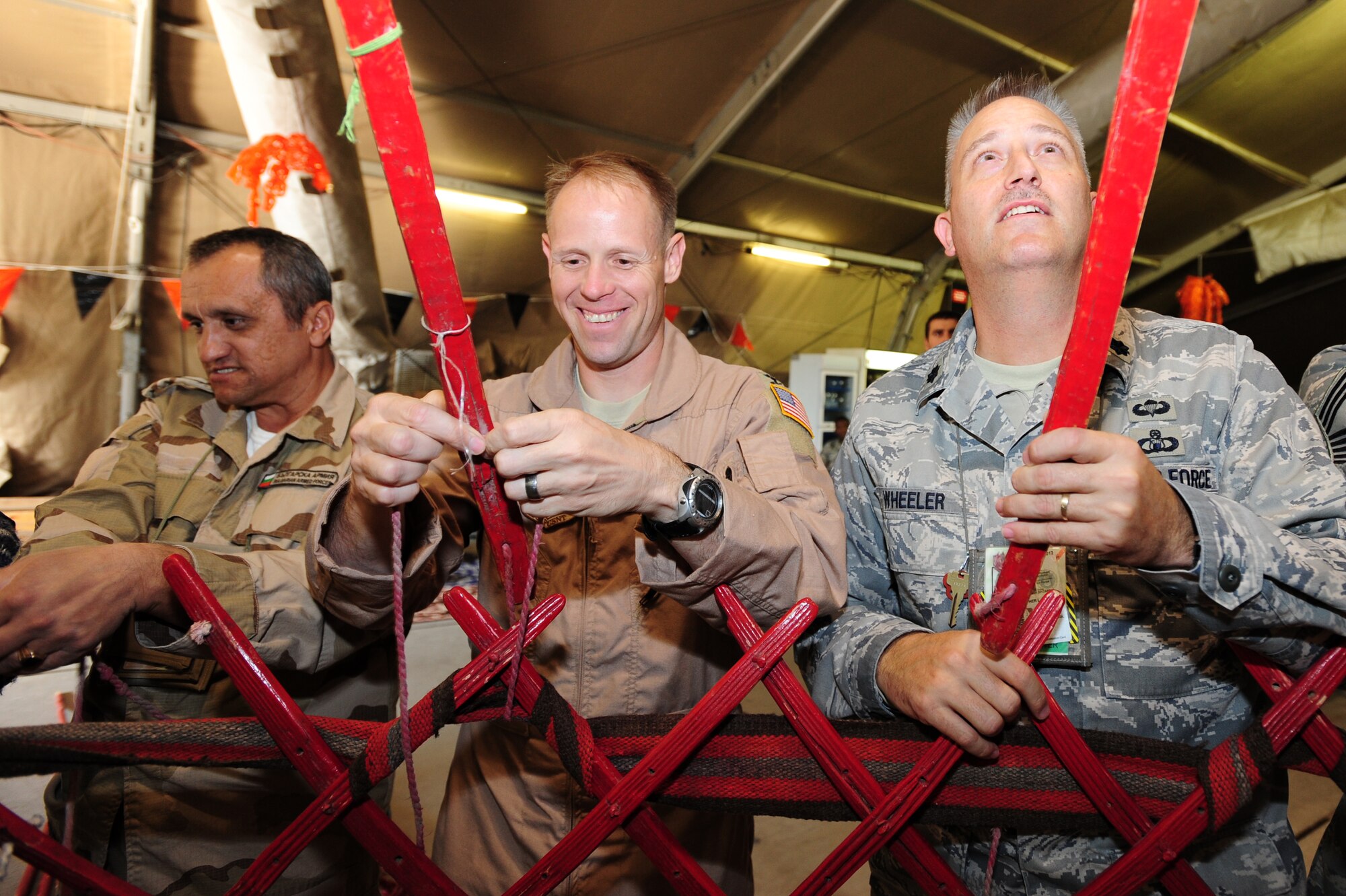 TRANSIT CENTER AT MANAS, Kyrgyzstan -- Col. Blaine Holt, 376th Air Expeditionary Wing commander, and Lt. Col. Christopher Wheeler, 376th Expeditionary Mission Support Group deputy commander, along with a coalition partner construct a traditional Kyrgyz Yurt at the Transit Center as part of Kyrgyz Culture Day, Oct. 24, 2009. (U.S. Air Force photo/Senior Airman Steele C. G. Britton)