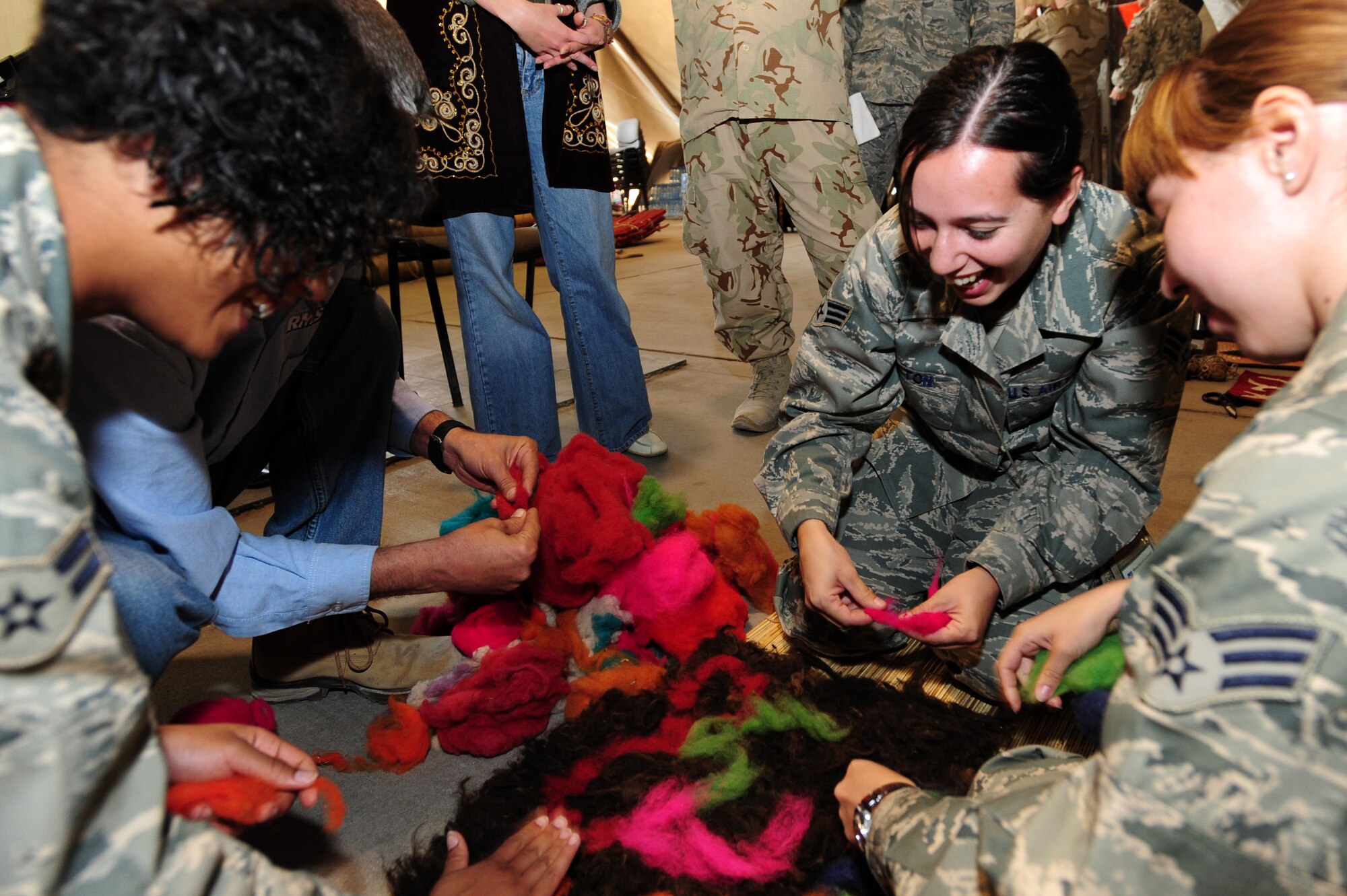 TRANSIT CENTER AT MANAS, Kyrgyzstan -- Senior Airmen Alaina Acton (center) and Maria Gates (right) design a carpet with Airman 1st Class Mariah Ham (left) during Kyrgyz Culture Day at the Transit Center, Oct. 25, 2009. (U.S. Air Force photo/Senior Airman Steele C. G. Britton)