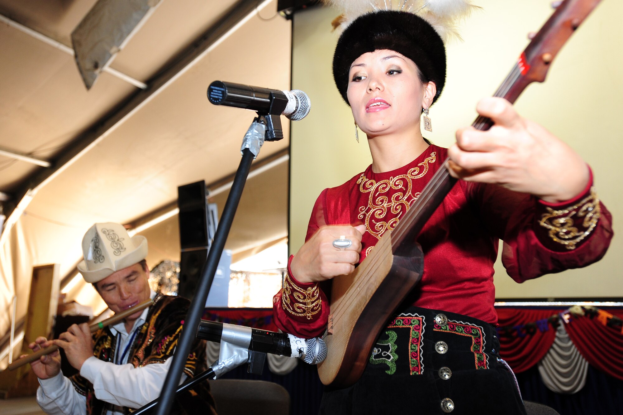TRANSIT CENTER AT MANAS, Kyrgyzstan -- Gulinara Raimalieva plays a komuz while Sovet Adrakhaev plays a flute as part of Kyrgyz Culture Day at the Transit Center, Oct. 24, 2009. (U.S. Air Force photo/Senior Airman Steele C. G. Britton)