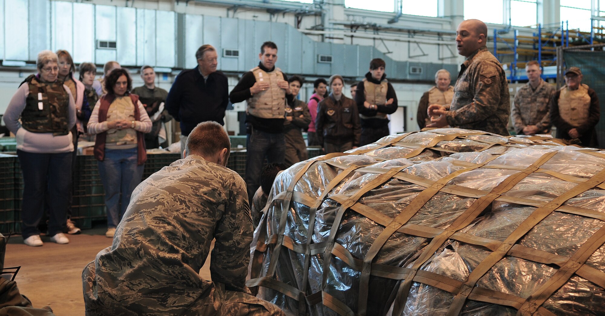 RAF MILDENHALL, England -- Staff Sgt. Ed Bourgeois, 100th Logistics Readiness Squadron, describes how one of his Airmen builds a pallet for military air transport to local dignitaries here Oct. 29. Sixteen honorary commanders plus their guests participated in the Team Mildenhall Honorary Commanders' Deployment Day by walking through mock deployment procedures. (U.S. Air Force photo/Senior Airman Thomas Trower)