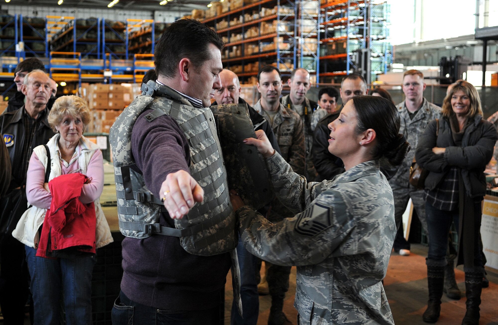 RAF MILDENHALL, England -- Master Sgt. Patricia Vandergrift, NCO in charge of war readiness, fits Clive Springett, 100th Communications Squadron honorary commander, with individual body armor here Oct. 29. Mr. Springett participated in the Team Mildenhall Honorary Commanders' Deployment Day which familiarized local dignitaries with the deployment process. In all, 60 people participated in the scenario. (U.S. Air Force photo/Senior Airman Thomas Trower)