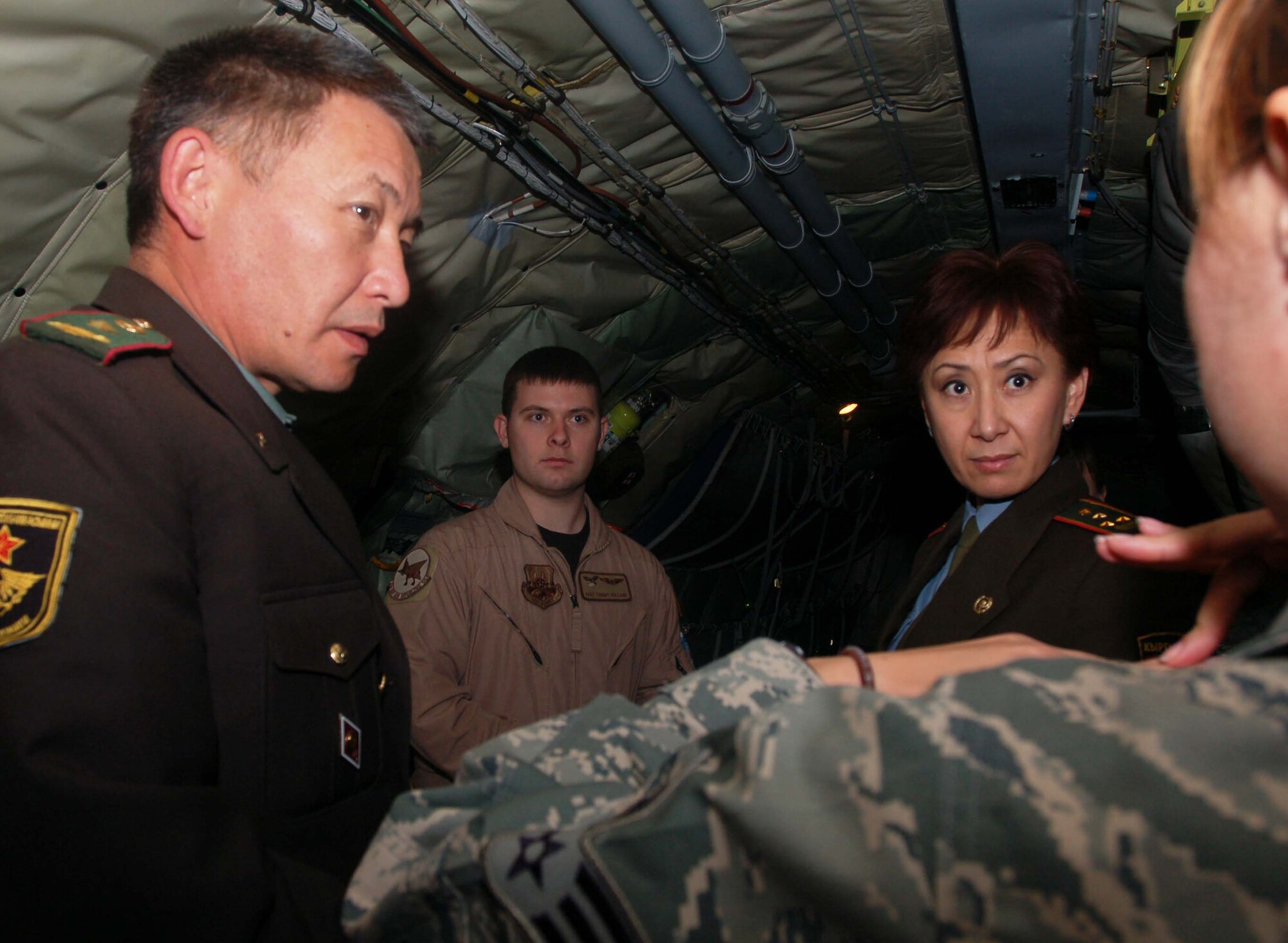 Senior Airman Maria Gates, 376th Air Expeditionary Wing coalition coordinator and linguist, translates into Kyrgyz (on behalf Staff Sgt. Tommy Holland) for a team of Kyrgyz Ministry of Defense medics about the KC-135 Stratotanker boom operation process during the team’s visit to the Transit Center at Manas Oct. 27.  The team of medics visited the Transit Center to learn about the Air Force mission and to gained insight from Airmen on how to properly equip their newly built hospital.  (U.S. Air Force photo/Staff Sgt. Olufemi Owolabi)