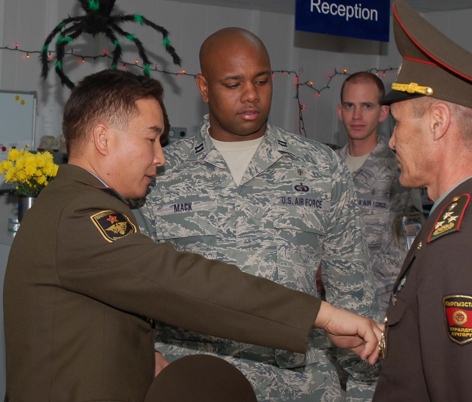 Captain Ronnie Mack, 376th Expeditionary Medical Group, learns about the Kyrgyz military badges, patches and ranks structure during a visit of the Kyrgyz MOD medical officials to the Transit Center at Manas Oct. 27.  During the visit, the team of Kyrgyz medics led by Col. Iskender Abykeev learned about the Air Force mission and gained insight from Airmen on how to properly equip their newly built hospital.  (U.S. Air Force photo/Staff Sgt. Olufemi Owolabi) 