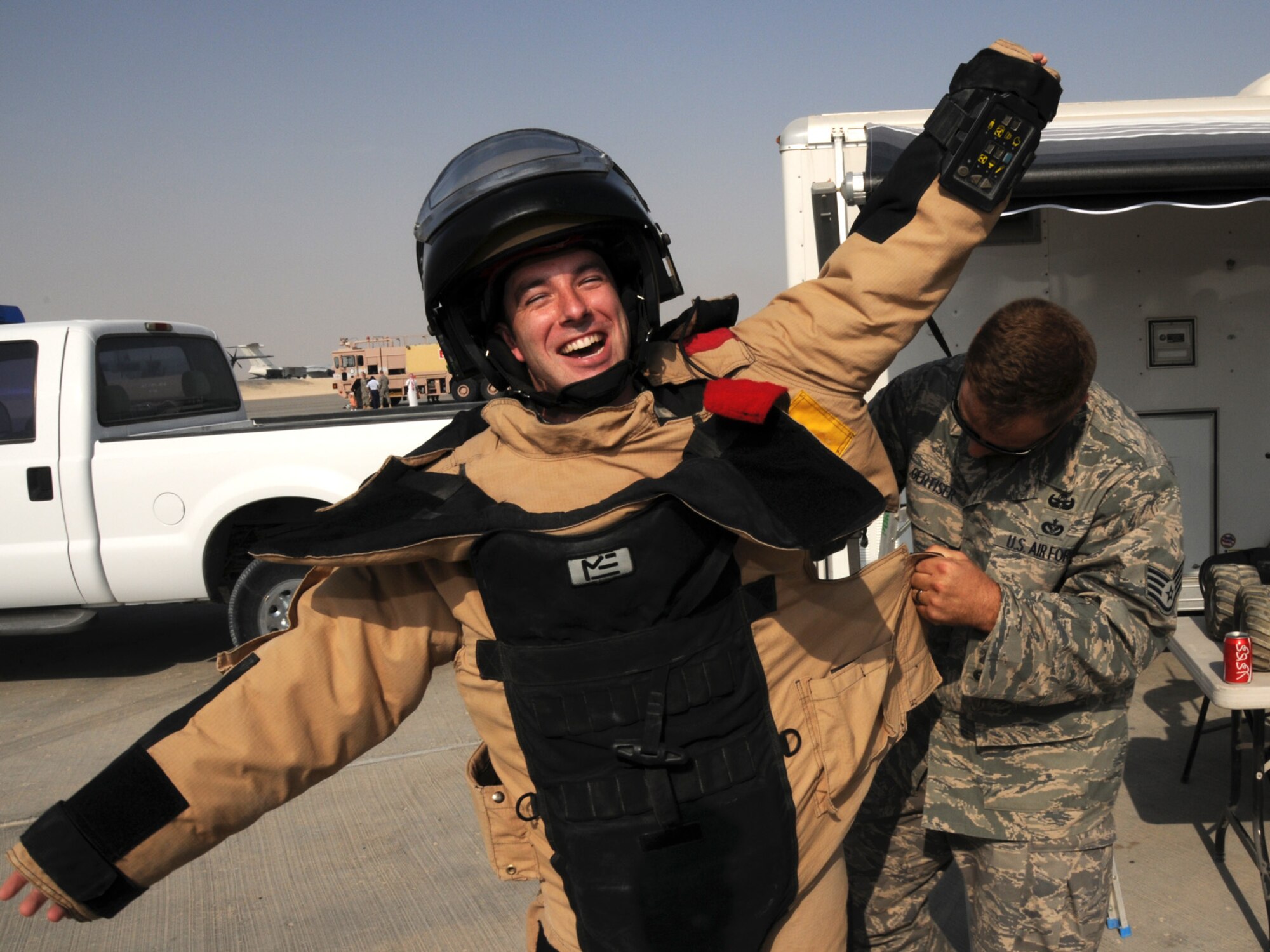 Senior Airman Ronald Abbate, 379th Expeditionary Contracting Squadron contingency contracting officer, tries on the EOD 9 bomb suit with the help of Staff Sgt. Neil Gertiser, 379th Expeditionary Civil Engineer Squadron explosive ordnance disposal NCOIC during Flightline Fest, Oct. 29, 2009. Flightline Fest is open to all base personnel and will showcase both the aircraft and specialized ground-based equipment and missions operating here. Airman Abbate is deployed from Eilson Air Force Base, Alaska. Sergeant Gertiser is deployed from Lackland Air Force Base, Texas. Both are deployed in support of operations Iraqi Freedom and Enduring Freedom. (U.S. Air Force Photo/Tech. Sgt. Jason W. Edwards)