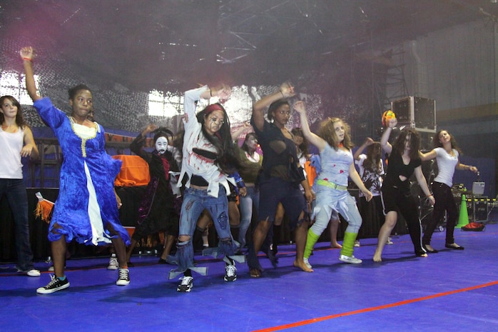 The Matthew C. Perry High School cheerleaders dance to “Thriller” by Michael Jackson at the Marine Corps Community Services children’s Halloween party at the IronWorks Gym here Saturday. After the performance, community members participated in a costume contest, enjoyed candy, a 6-foot Frankenstein cake, food and beverages, and children played in the bounce houses.