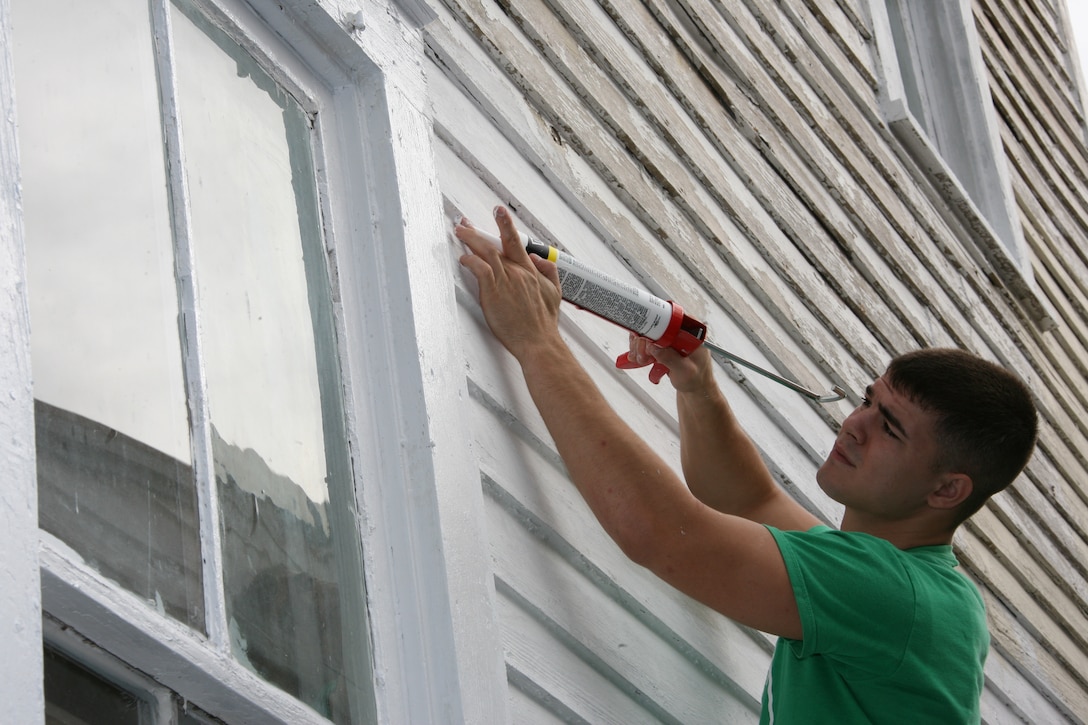 Lance Cpl. James A. Jones, an aviation electronic micro miniature/instrument and cable repair technician with Marine Aviation Logistics Squadron 14, caulks holes in a 90-year-old structure that will provide a home to disadvantaged young pregnant women in New Bern, N.C., Oct. 31.