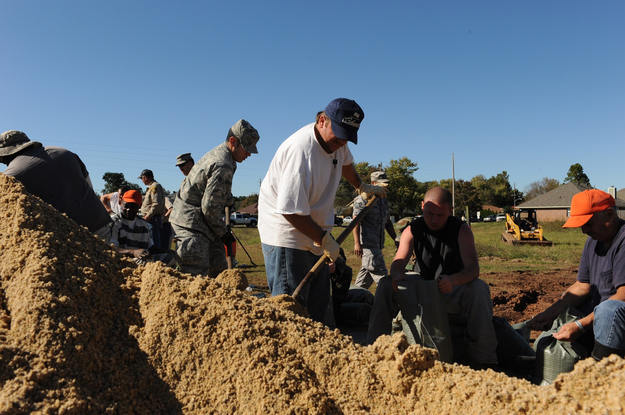 Airmen from Barksdale Air Force Base and local community members work together to fill sand bags for a levee to hold back floodwaters in Bossier City, La. The Airmen, at the request of state and local officials, have been working nonstop since early Saturday morning to reinforce the levee containing Red Chute Bayou. More than 300 Airmen have assisted with filling and hauling sandbags in a massive effort under immediate response authority. (U.S. Air Force photo by Staff Sgt. Mike Andriacco)