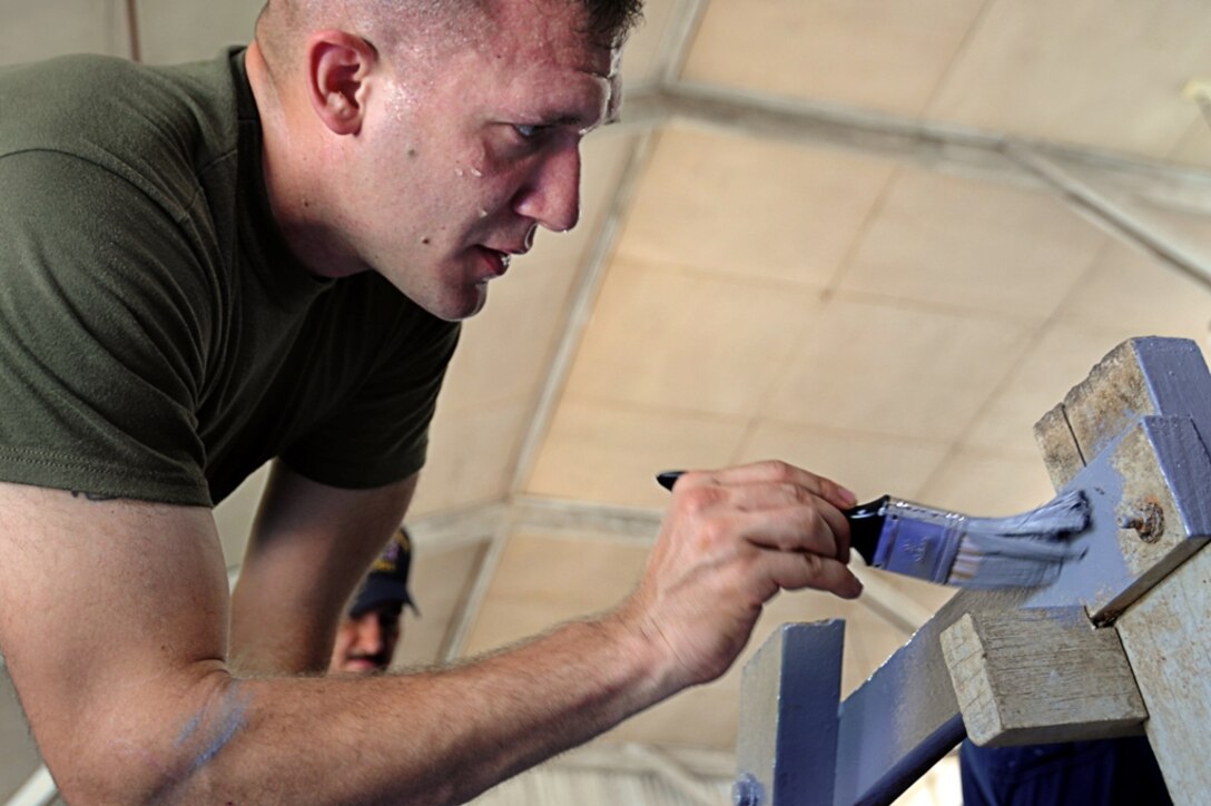 Sgt. John Woolums, a Fort Wayne, Ind., native, with the 11th Marine Expeditionary Unit, paints a table at a community service project at the Baan Ao Bor Nam School in Phuket, Thailand, Oct. 31, during a port visit. More than 20 service personnel currently deployed aboard USS Bonhomme Richard, painted tables, chairs, and interacted with the school’s students.