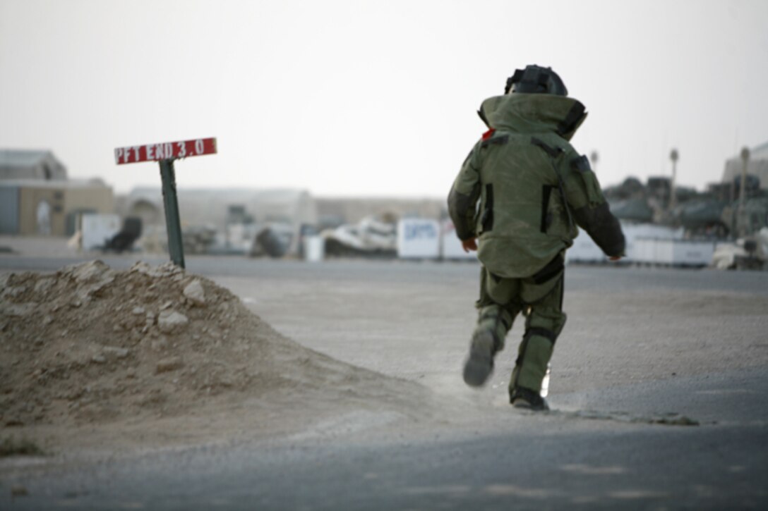 Staff Sgt. Jeremy Herbert, the explosive ordnance disposal team leader for Marine Wing Support Squadron 271, Sahl Sinjar detachment, crosses the finish line of a world record breaking one-mile run in an EOD bomb suit aboard Sahl Sinjar Airfield, Iraq, Sept. 1, 2009. Herbert’s new world record of 9:58.8 surpassed the previous record by nearly 15 seconds.