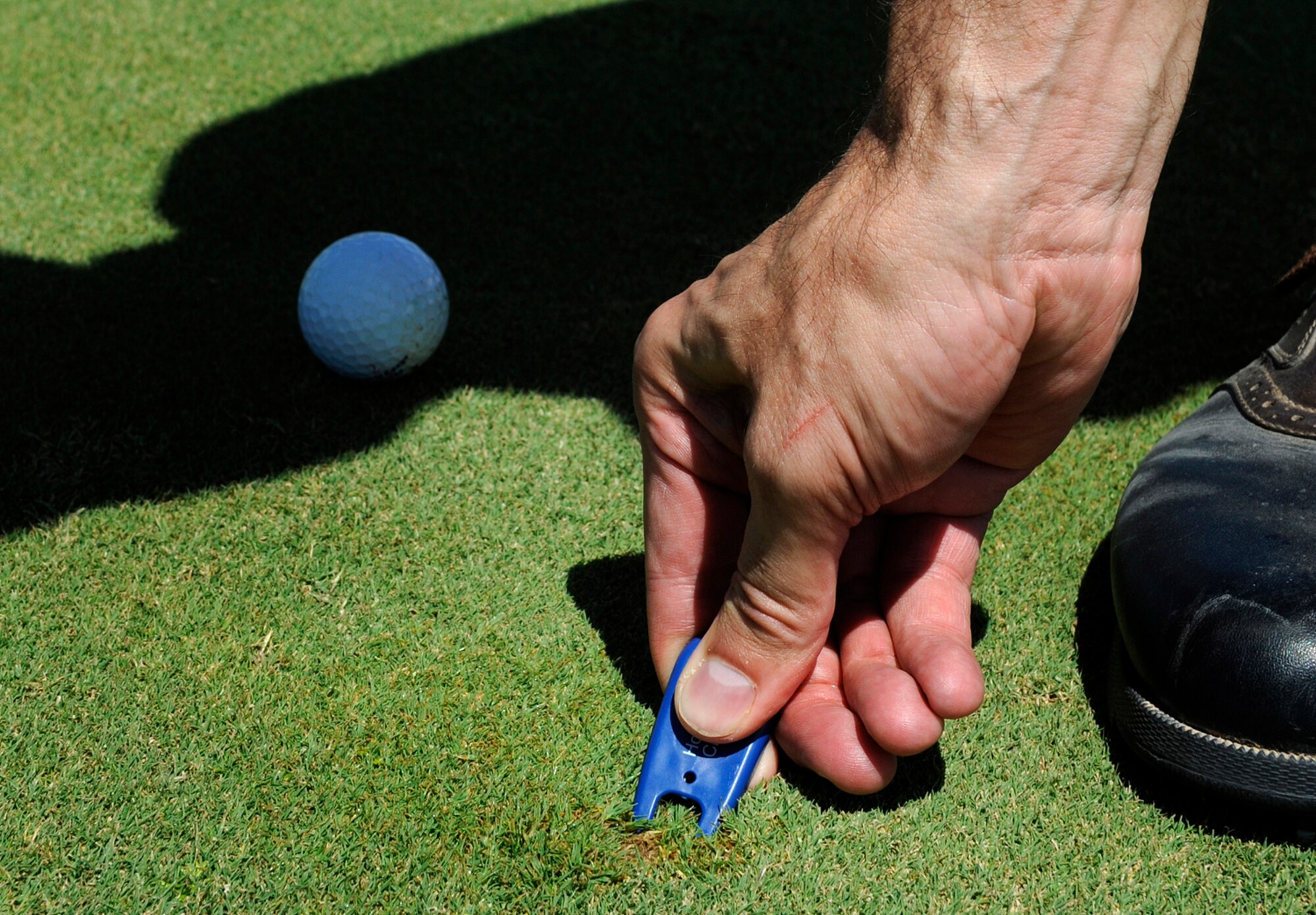 HOLLOMAN AIR FORCE BASE, N.M. -- James Alling, 49th Maintenance Operations Squadron Training Management section chief, uses a divot tool to repair the grass at the Apache Mesa Golf Course here Aug. 27. Alling was competing in a golf tournament sponsored by the Chief's Group to fund quality of life initiatives around base. (U.S. Air Force photo by Senior Airman Tiffany Trojca)