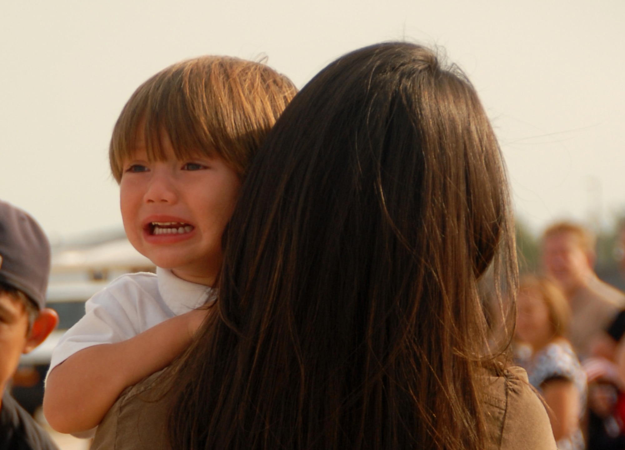 Family members of the 815th Airlift Squadron "Flying Jennies" bid farewell to their loved ones, who departed Keesler Air Force Base, Biloxi, Miss. Sept. 1 for their deployment to Southwest Asia. Maribel Barberi comforts her son Isaiah as he watches is dad, Captain Dominic Barberi board the C-130J-30. (Air Force Photo by Senior Airman Tabitha Dupas)