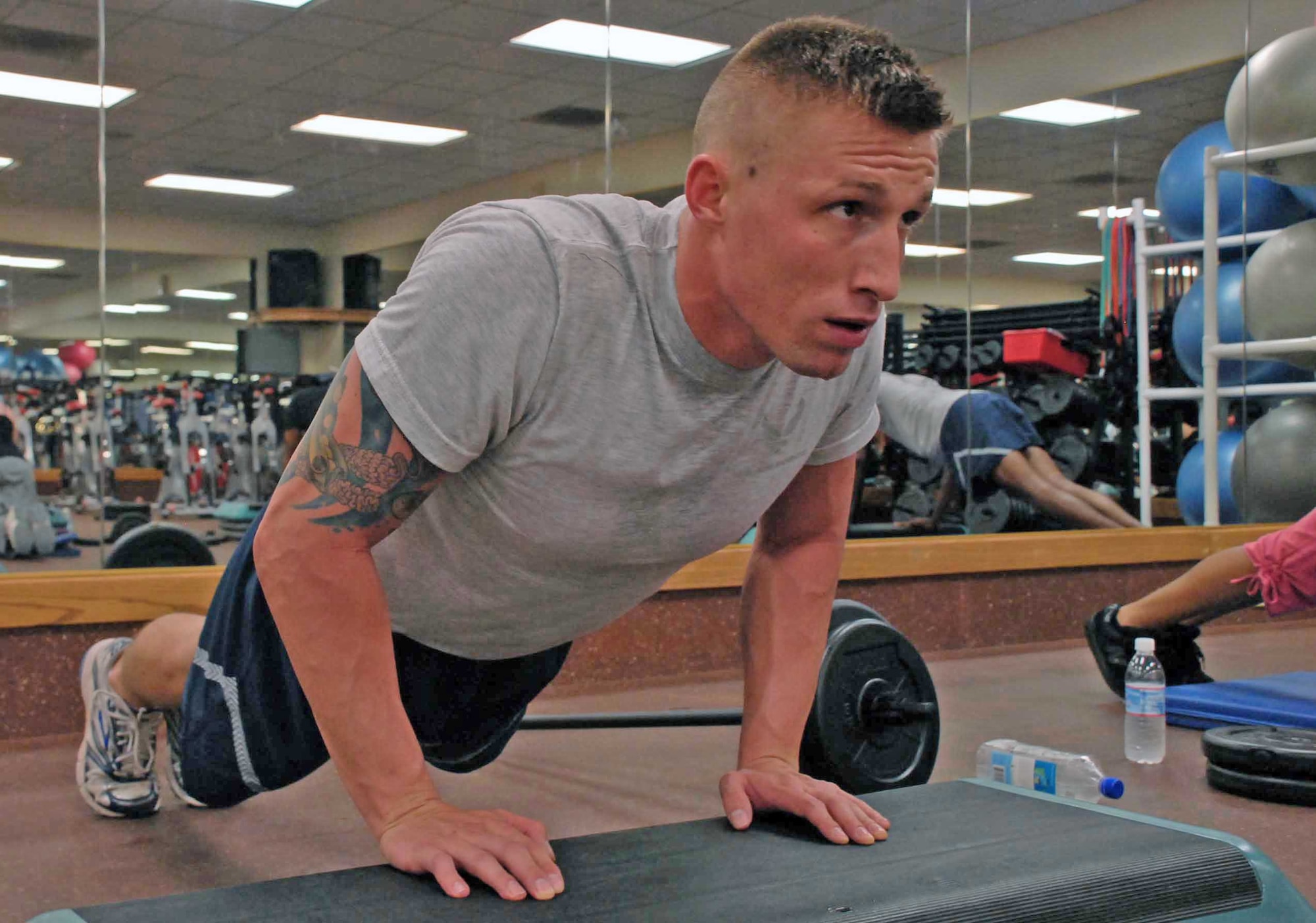 Airman 1st Class Christopher McDowell works out his triceps Aug. 17, 2009, at the fitness center at Beale Air Force Base, Calif. Airman McDowell is one of the certified instructors for the new Body Pump program recently implemented to promote fitness at Beale.  (U.S. Air Force photo/Sandy Healy)