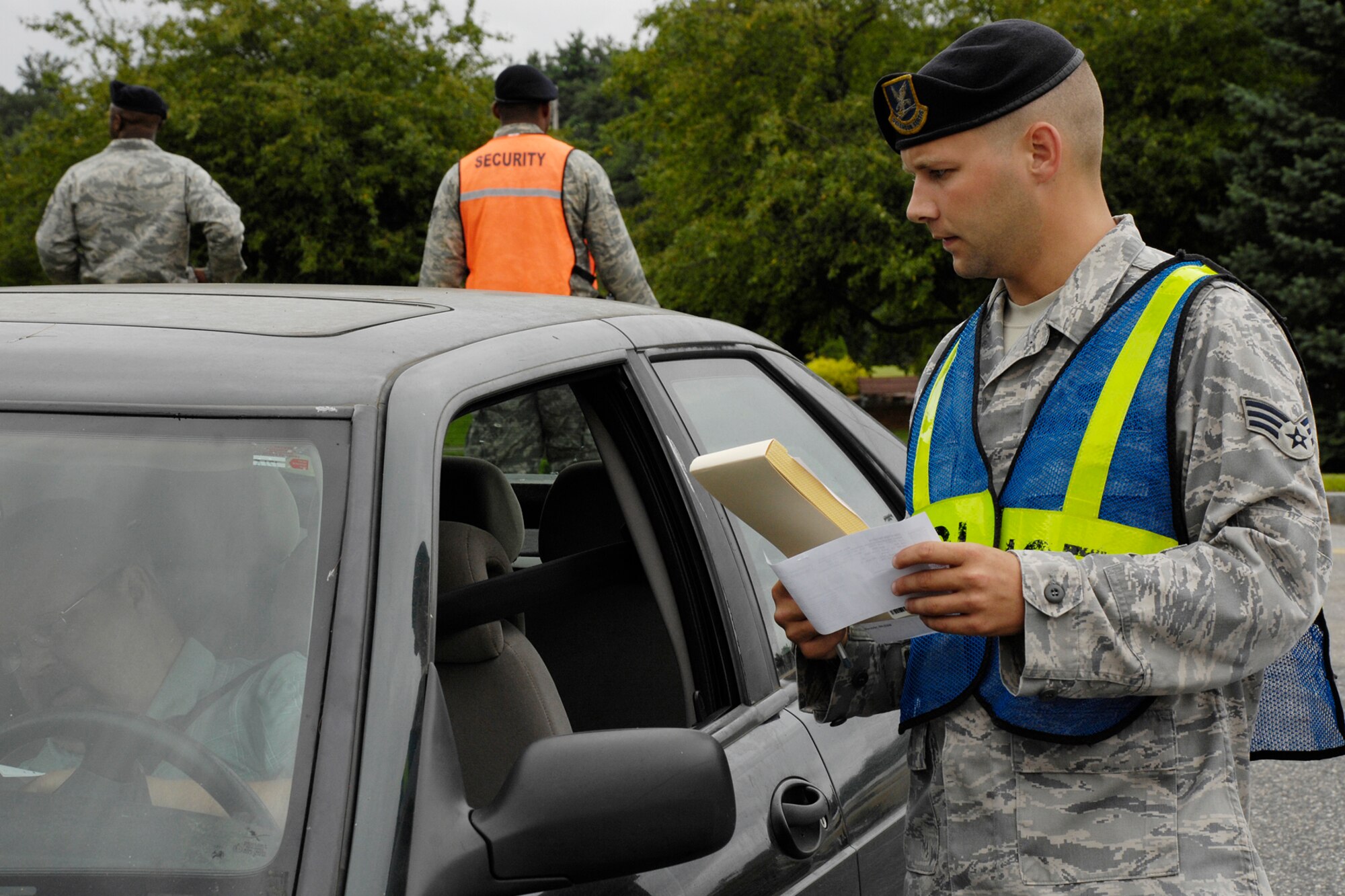 HANSCOM AIR FORCE BASE, Mass. -  Senior Airman Cody Gray, 66th Security Forces Squadron resource protection, issues a ticket to a motorist on Hanscom for a driving infraction on Barksdale Street Aug. 13. Members of the 66 SFS issued most of the fines for using a cellular phone while driving or not wearing a seatbelt. (U.S. Air Force photo by Linda LaBonte Britt)