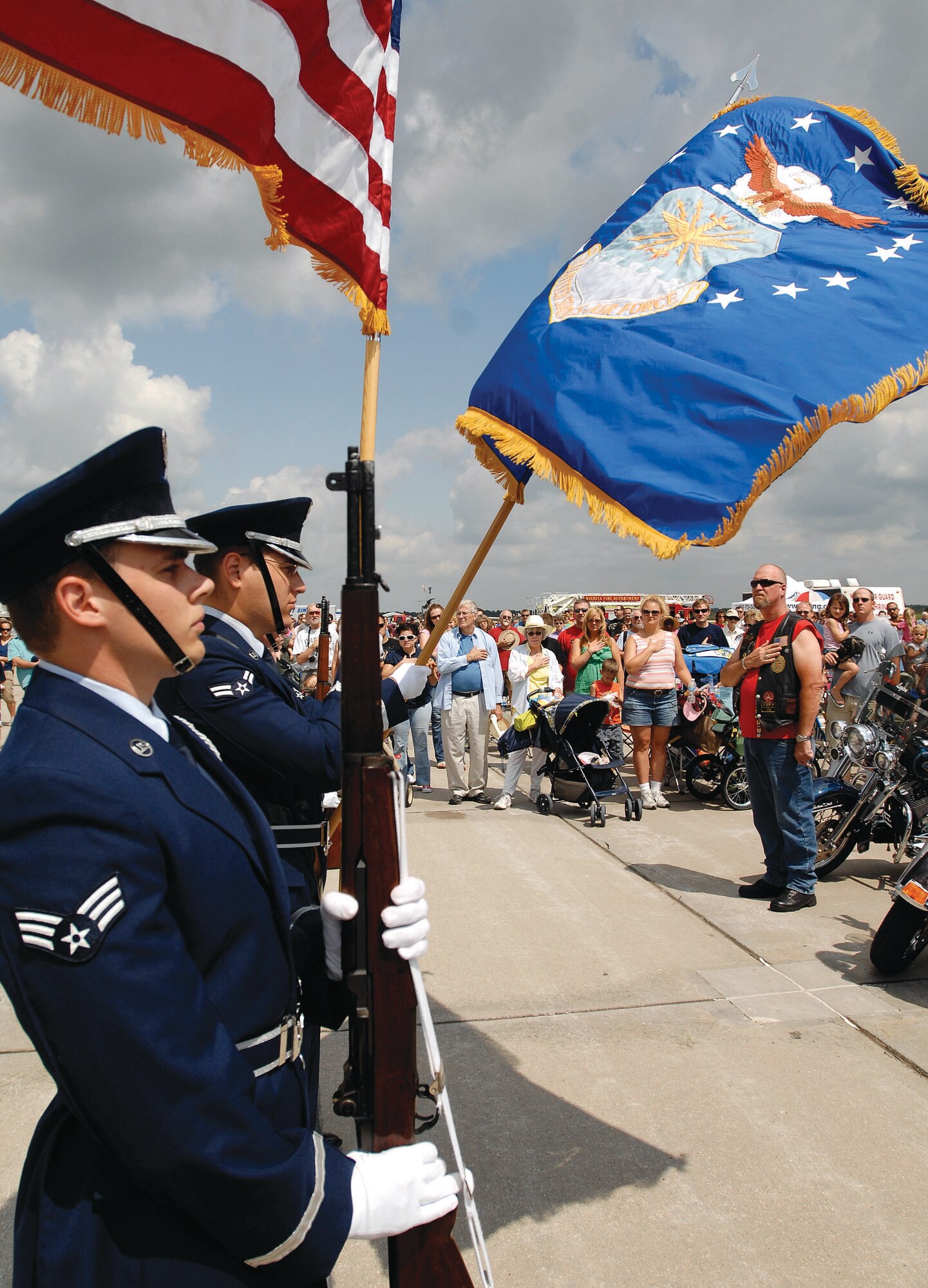 Members of the McConnell Air Force Base, Kan., Honor Guard present the colors to a crowd of spectators at the Wichita Flight Festival, Aug. 29 at the Colonel James Jabara Airport, Wichita, Kan. before an afternoon of aerial demonstrations (U.S. Air Force photo by Senior Airman Jessica Lockoski)